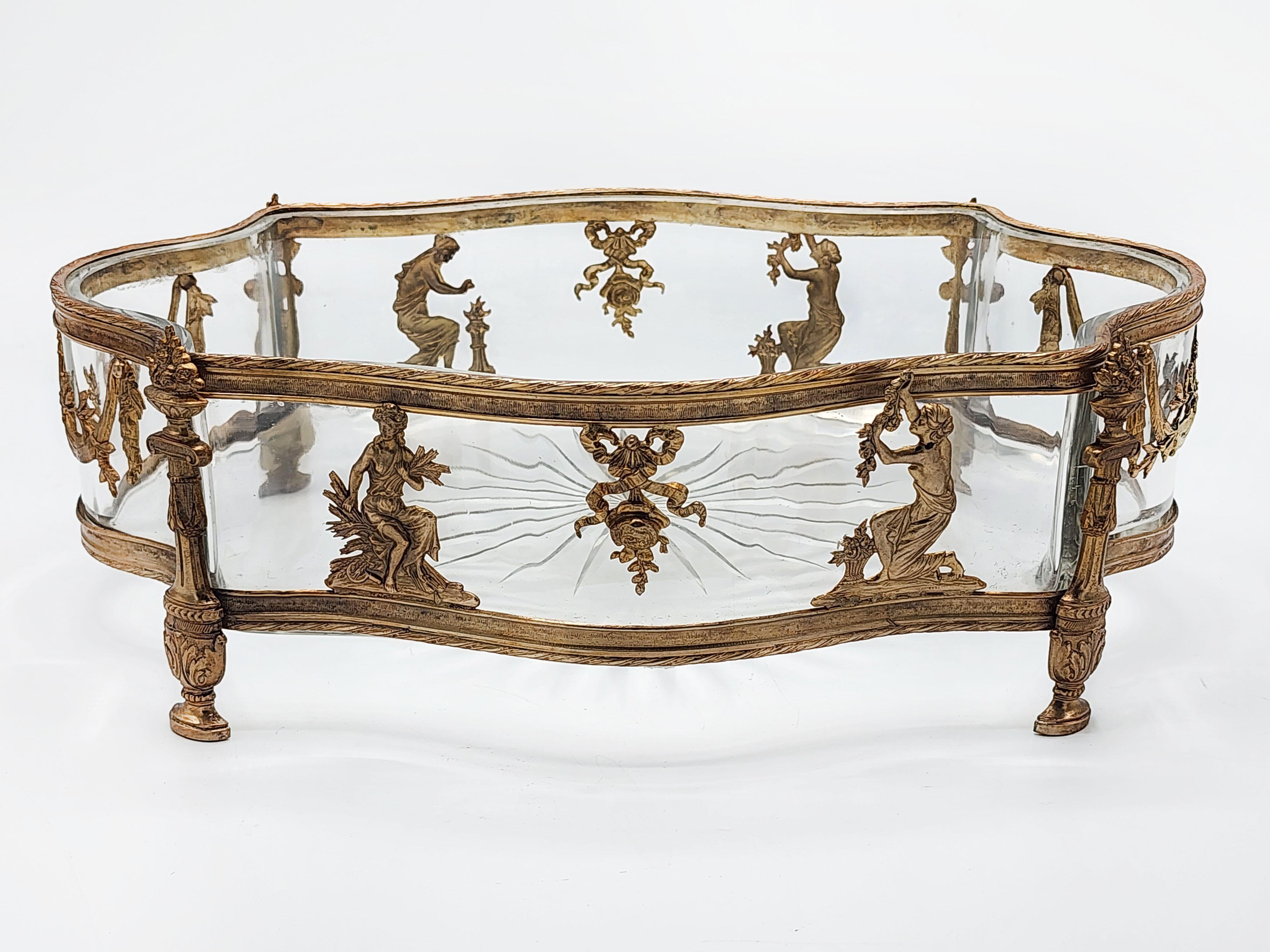 Empire planter with bronze mount 19th Century
Antique cut glass planter with a gilt bronze mount with a neoclassical design with 4 ladies, two on each side with ribbons and ornaments.
Measures:
Height: 10 centimeters
Length: 30 centimeters
Depth: 20