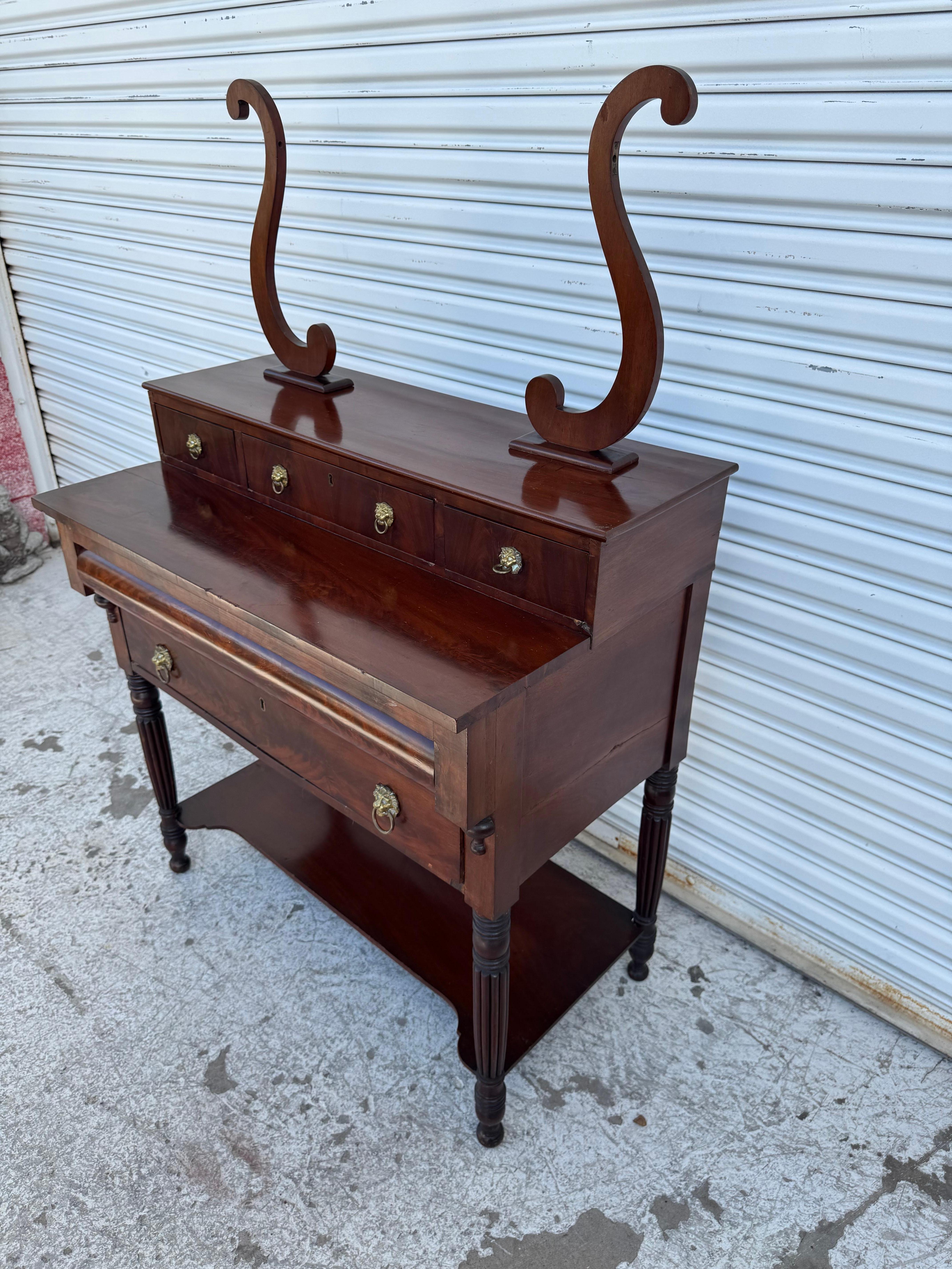 This vanity comes from the late 19th century.
The Empire Revival period was between 1880-1900.
This piece is made with a nice Flaming Mahogany giving it
a Biedermeier feel.
It has 4 small upper drawers and a lower drawer for storage.
There's also a 