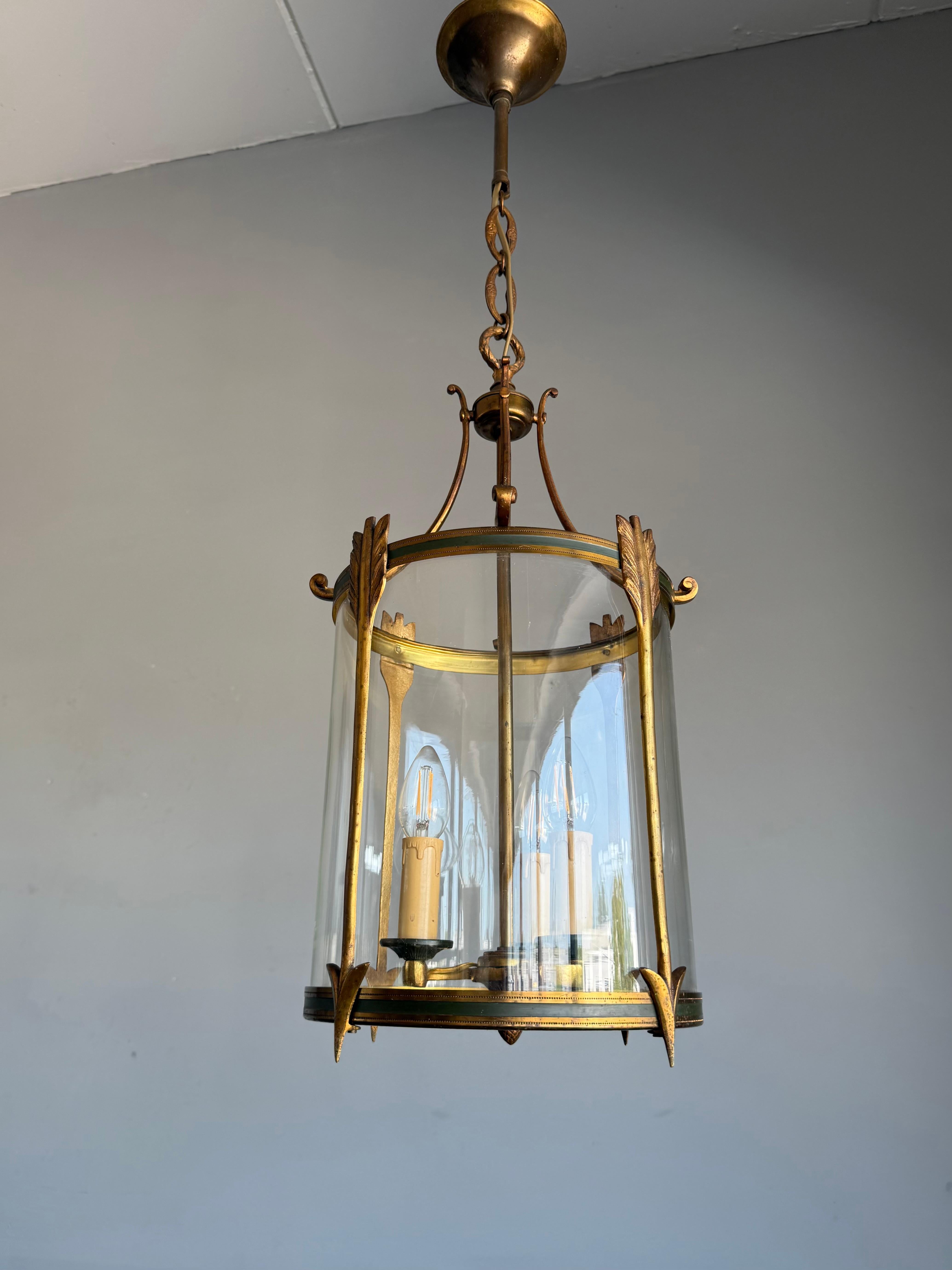 Good size, great condition bronze hallway pendant with unique antique blown circular glass.

This striking French lantern is a refined example of Empire Revival craftsmanship, dating to the early 1900s. It features a cylindrical body made of