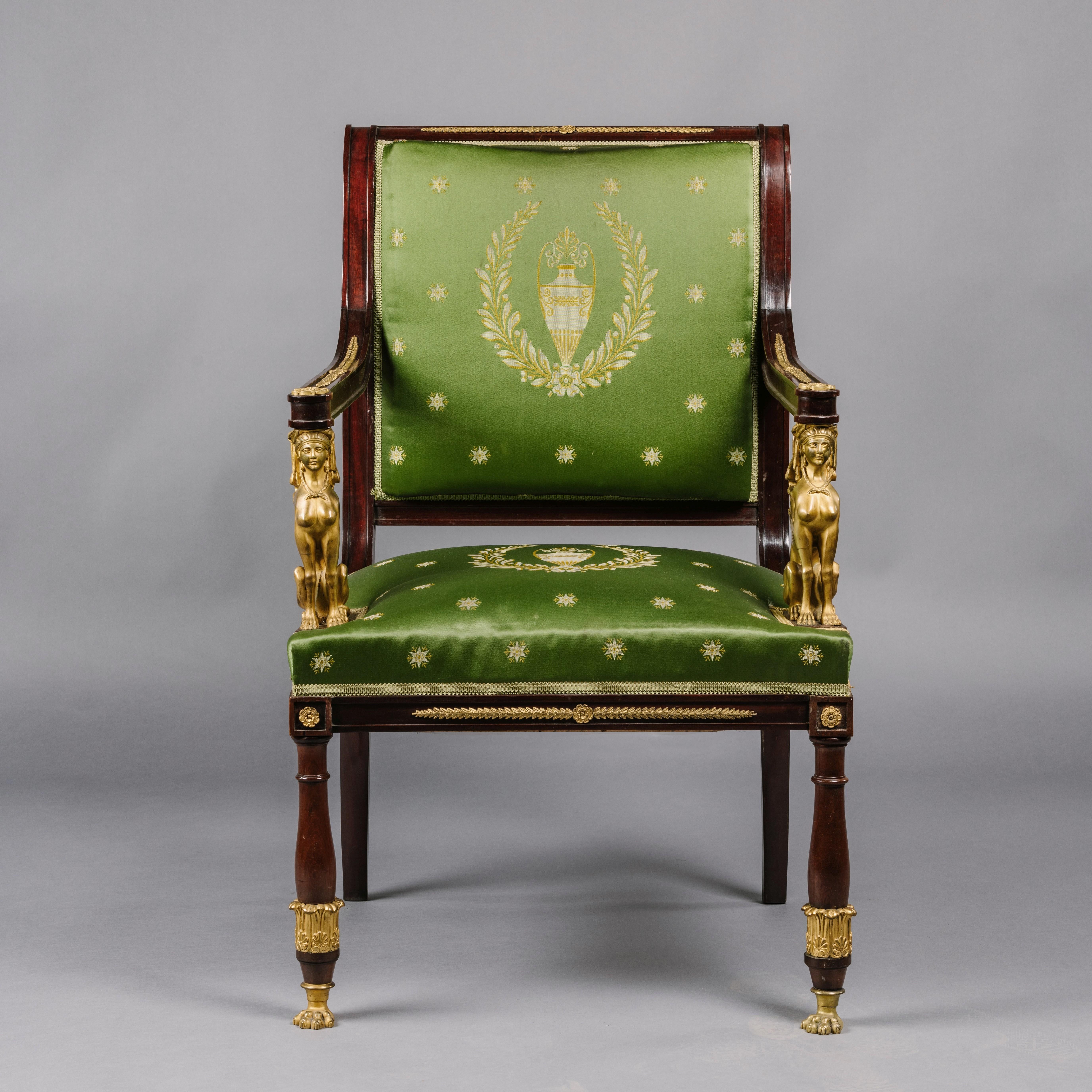 A fine empire revival gilt-bronze mounted mahogany fauteuil.

This elegant armchair has a scrolled mahogany frame with a padded upholstered back and seat, the arms put down on finely cast gilt-bronze seated sphinx above an apron mounted with
