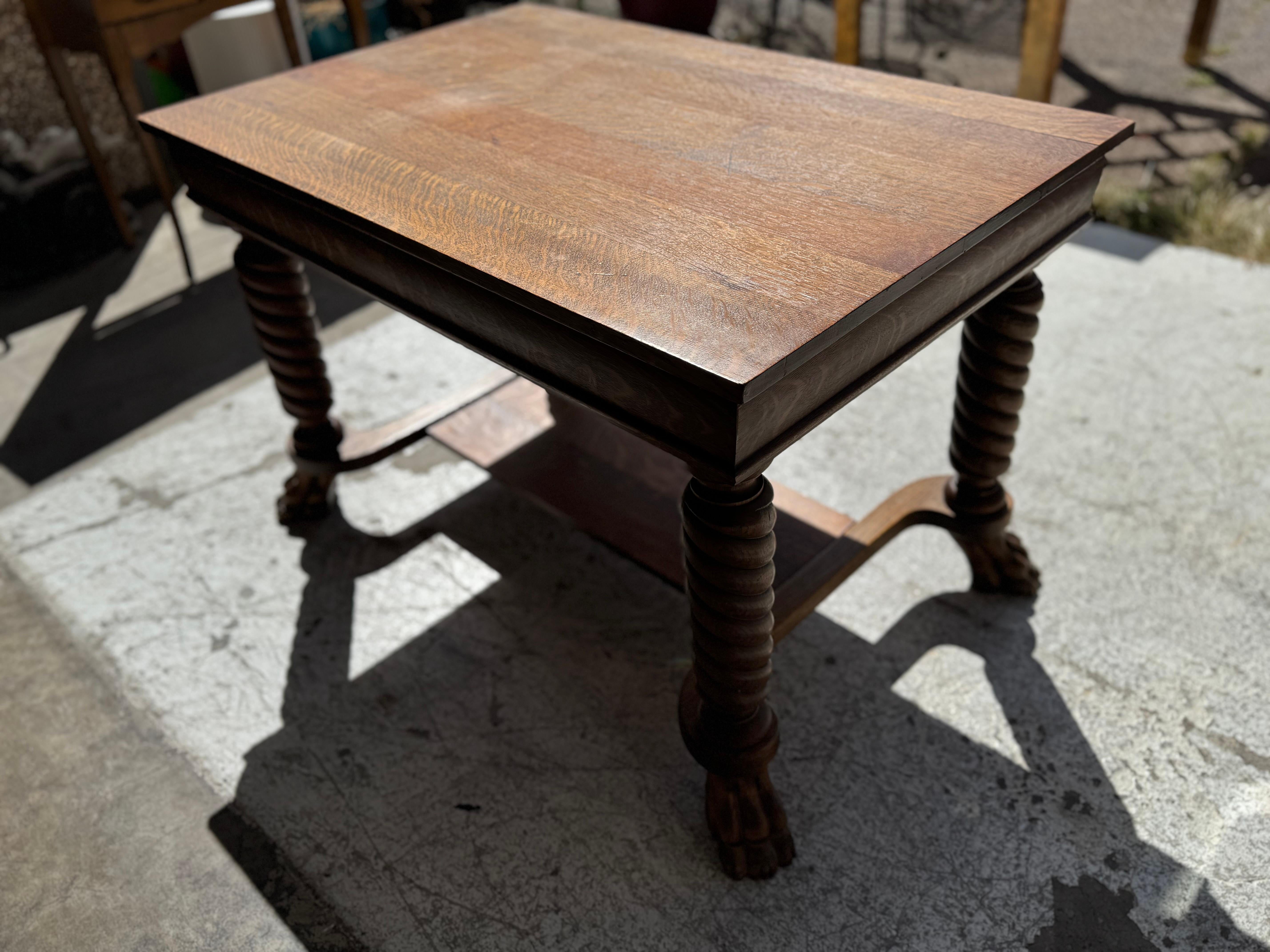 This desk was made at the turn of the 20th century.
Its made of quarter sawn oak. The legs are turned and fashioned
in a spiral shape. The legs end in beautifully carved hoofed feet.
It also has a lower shelf for storage or as a foot rest.

There's