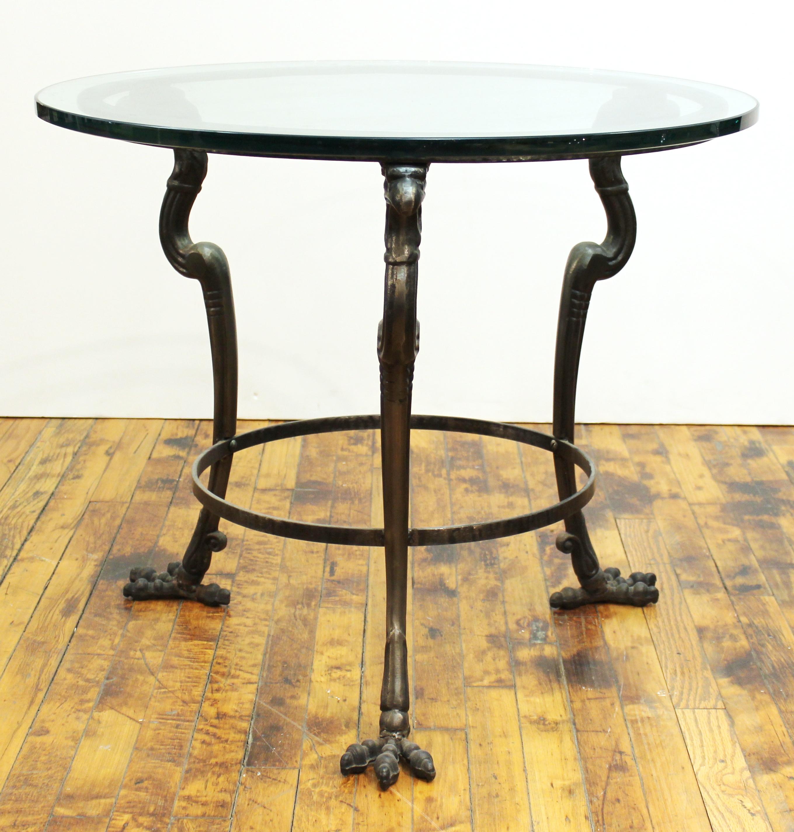 Empire revival style modern tripod center table or side table with eagle heads and claw feet and circular glass top.