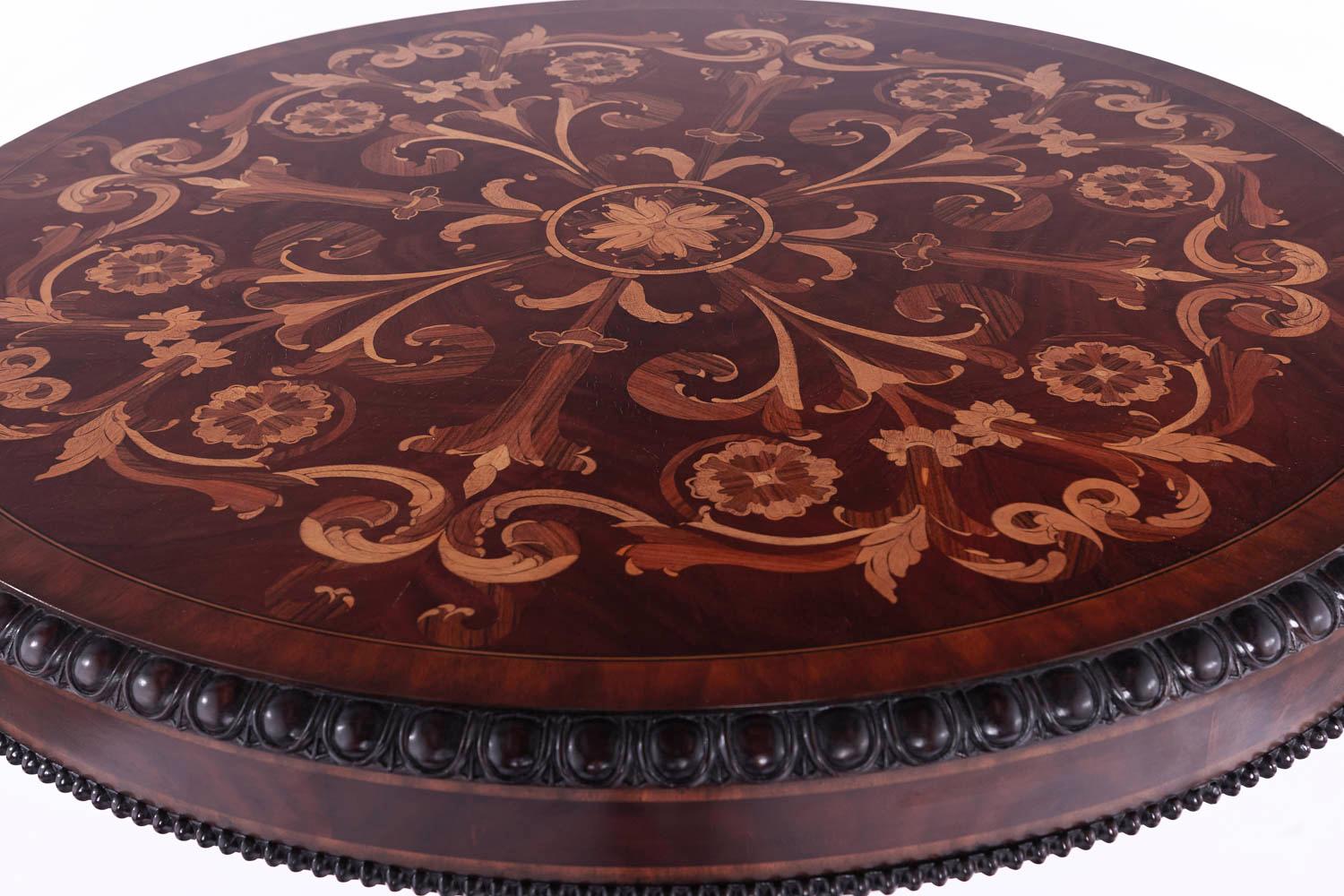 An elegant Empire style center table is made out of mahogany with marquetry veneers and the brass combination has exceptional quality and craftsmanship and has been professionally restored. This elegant circular center table is stained in mahogany