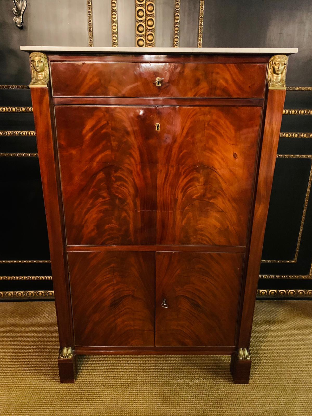 High quality Cuban mahogany on solid oak. gold-plated, finely chased fittings Central lock with a special key.
Architecturally structured front. Rectangular body on 2 high feet with bronze fittings.
Equipped with two doors lockable with a rod.
