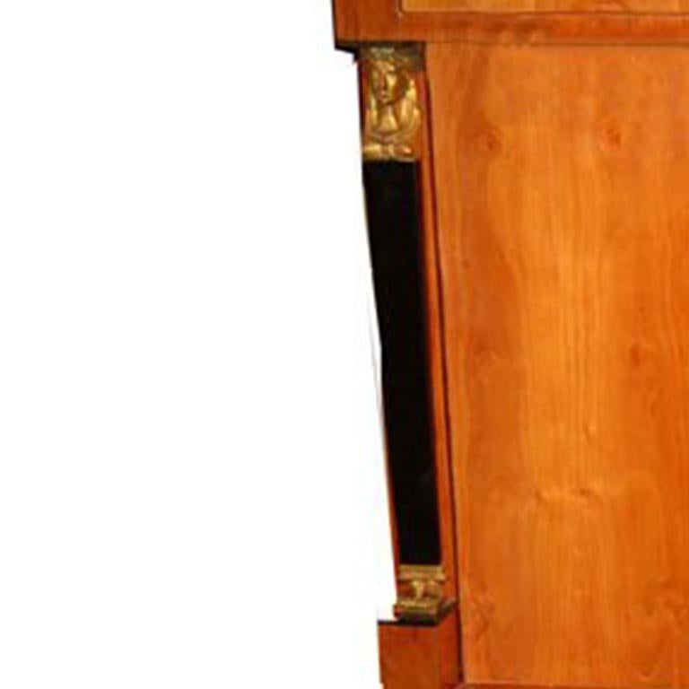 Empire Secretaire made of walnut and root wood with brass capitals and hardware. Three exterior drawers. Fall front writing surface w/five interior drawers and mirrored cubby hole.  Ebonized and precious woods inside.  Austria circa 1810.