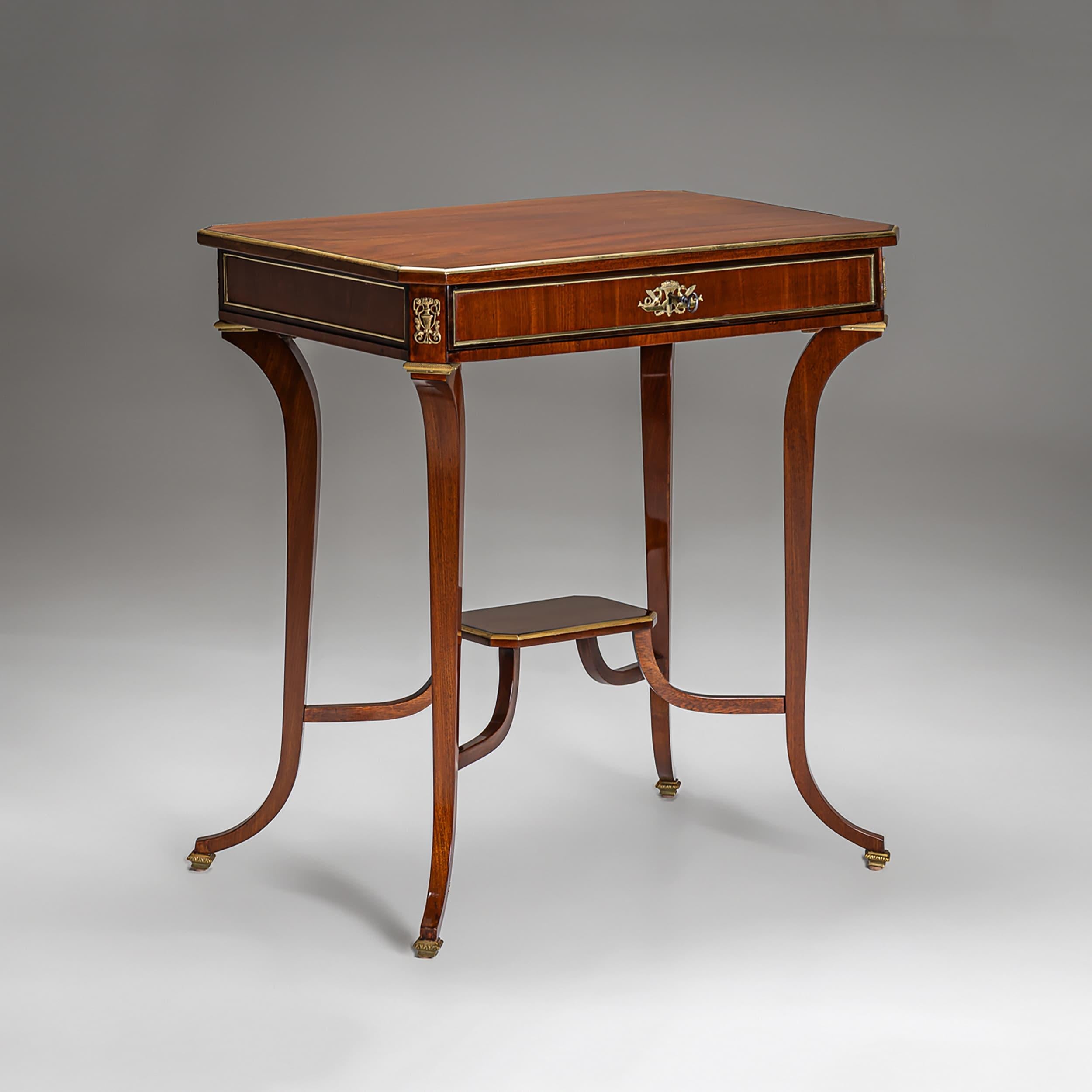Élégante table d'appoint Empire viennois en acajou, fabriquée vers 1810. La table comporte un seul tiroir et repose sur des pieds en forme de C gracieusement incurvés et dotés de sabots en laiton. Une étagère inférieure octogonale surélevée ajoute