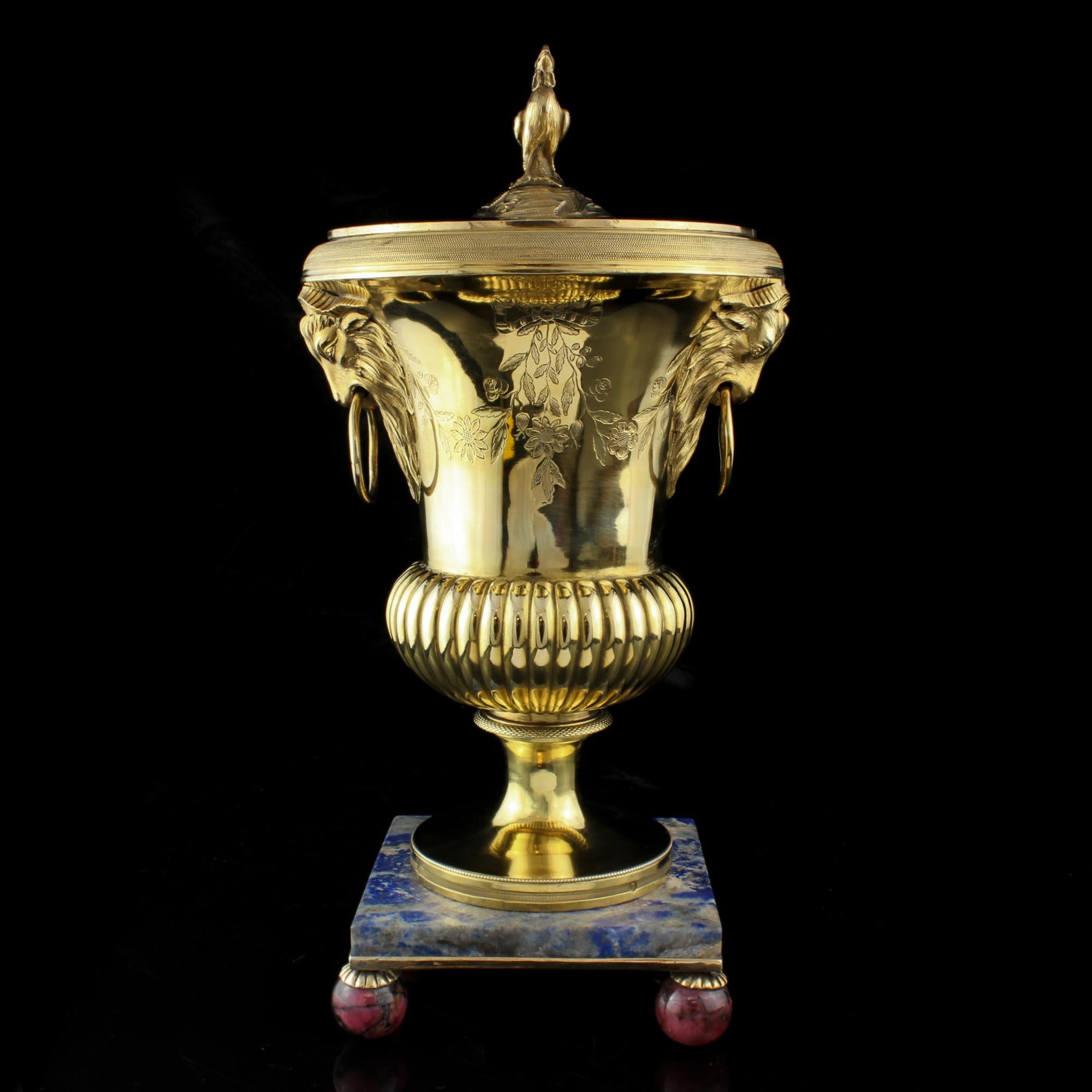 Vase et couvercle / urne antique française en argent doré avec couvercle en forme de coq
Monté sur une base en Lapis Lazuli avec des pieds en Rhodonite.
Avec deux poignées à anneau tombant en forme de masque de chèvre.
Créateur : Nicolas Richard