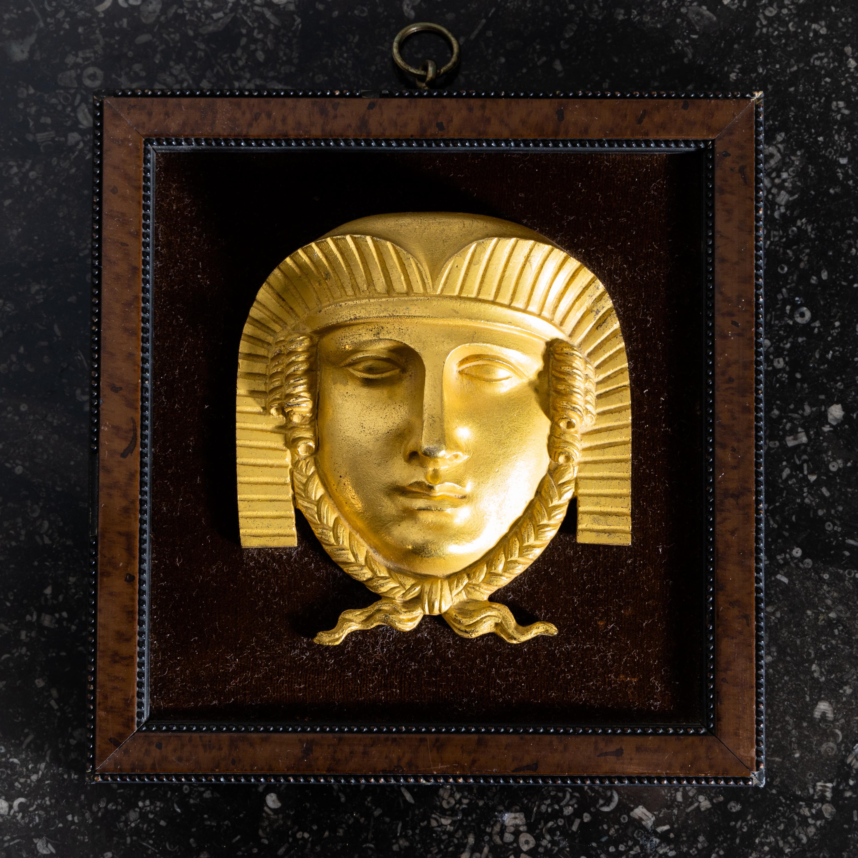 Maskaron der Sphinx aus feuervergoldeter Bronze im quadratischen Rahmen auf Samt gerahmt.