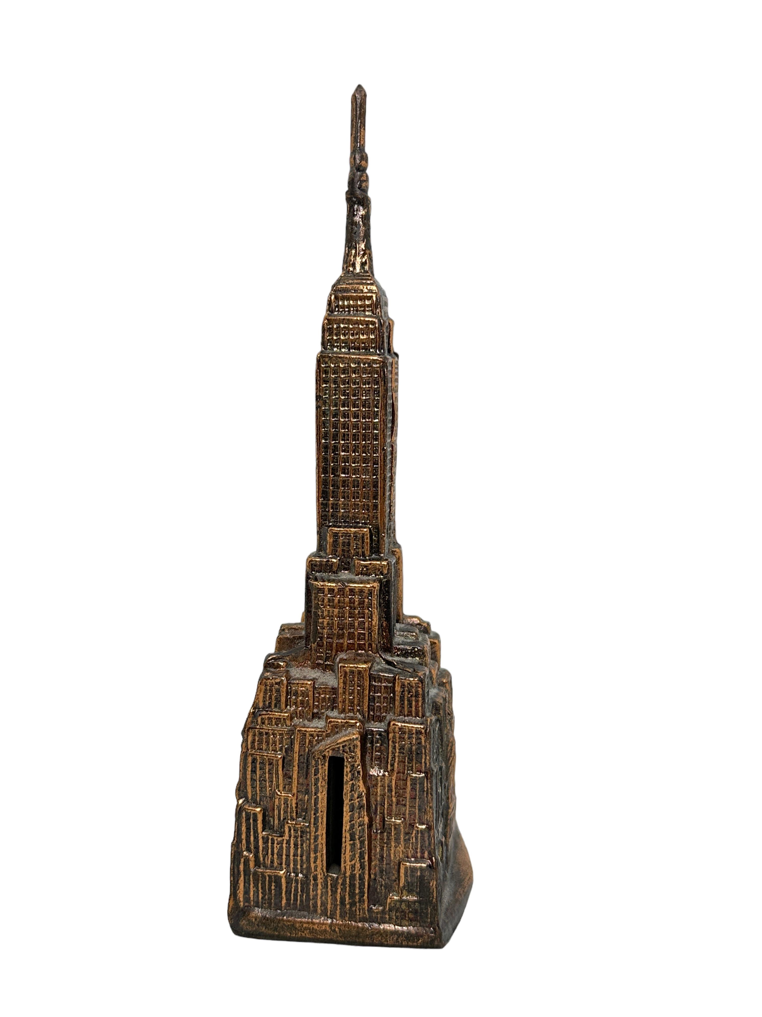 Gorgeous vintage metal money bank. Made of copper metal, this collectible bank, in the shape of New York’s Empire State Building, stands 7 5/8” tall. Nice addition to any collection, desktop, living room or children's room.