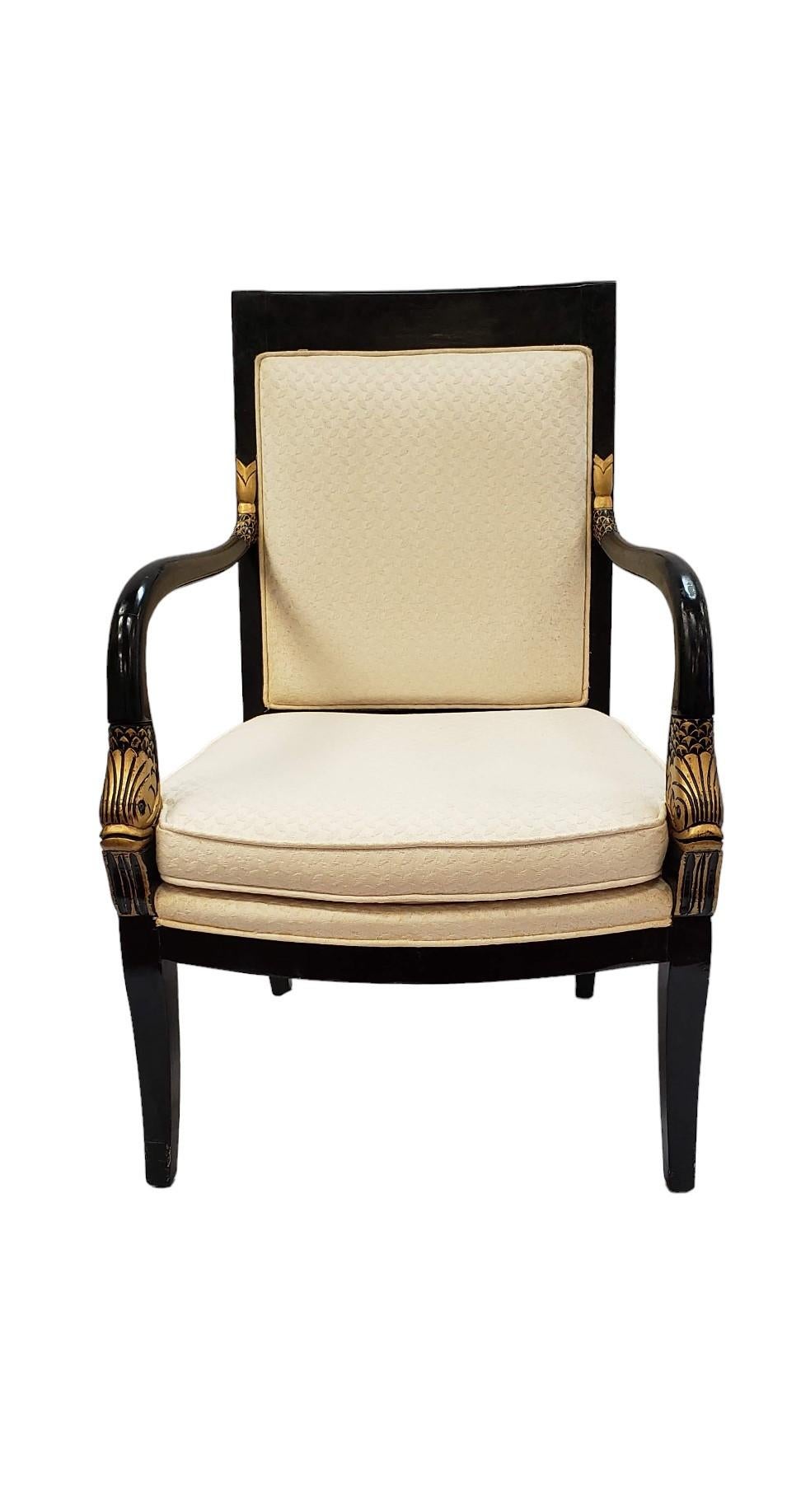 Este sillón de estilo Imperio combina la grandeza neoclásica con ricos detalles decorativos. El marco de madera lacada en negro se acentúa con cabezas de pato doradas talladas en la base de cada reposabrazos, un elegante guiño a la artesanía