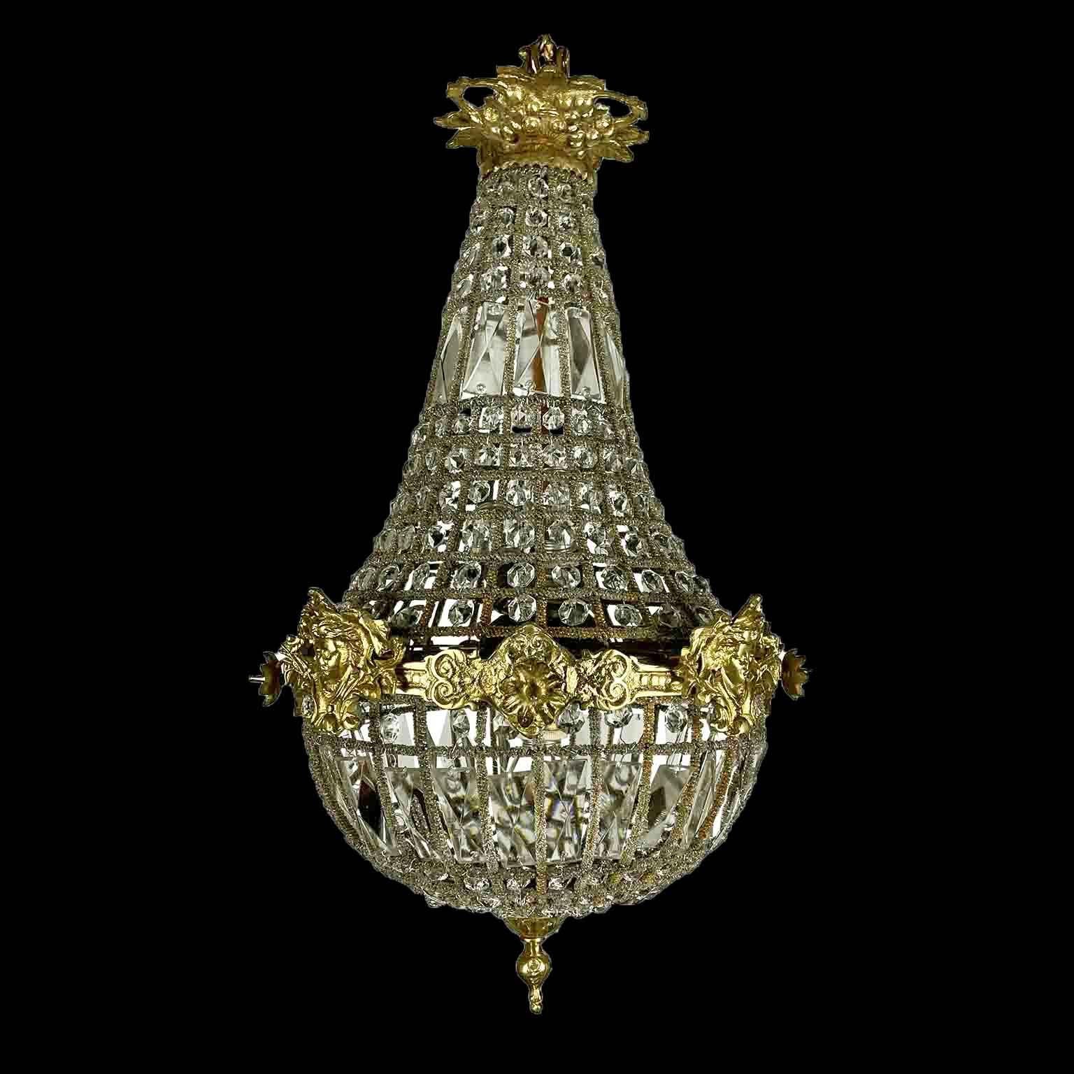 A late 20th century Empire style beaded crystal basket chandelier with a classical circular brass structure and three E27 lights inside.Light bulbs can be replaced unscrewing the bronze roses of the middle ring. Working wiring for European