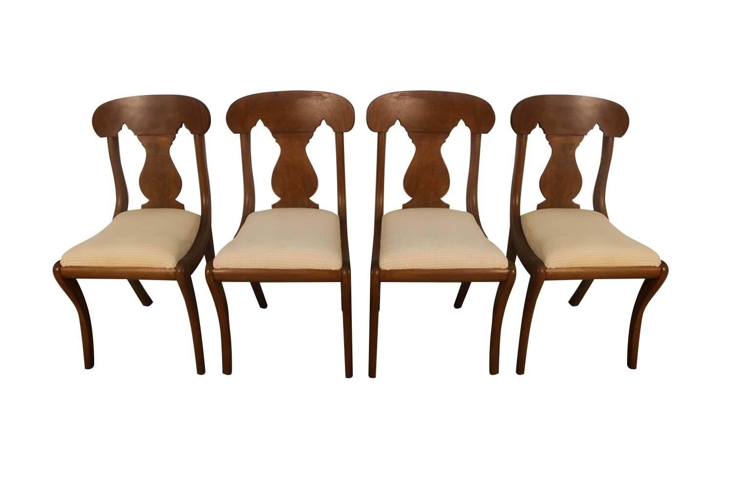 A set of four beautifully crafted Biggs Furniture mahogany Empire style dining chairs, circa first half of the 20th century. These sophisticated dining chairs are fashioned in the empire style and feature a hand crafted Honduran mahogany frame with