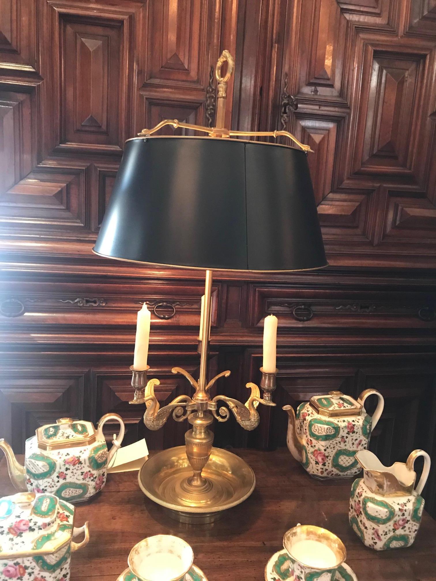 Empire style bouillotte table lamp candleholder in gold color on bronze. 

This table lamp has a centre pipe that holds the shade and which allows the shade height to be adjusted up or down. This adjustable feature is taken from the original