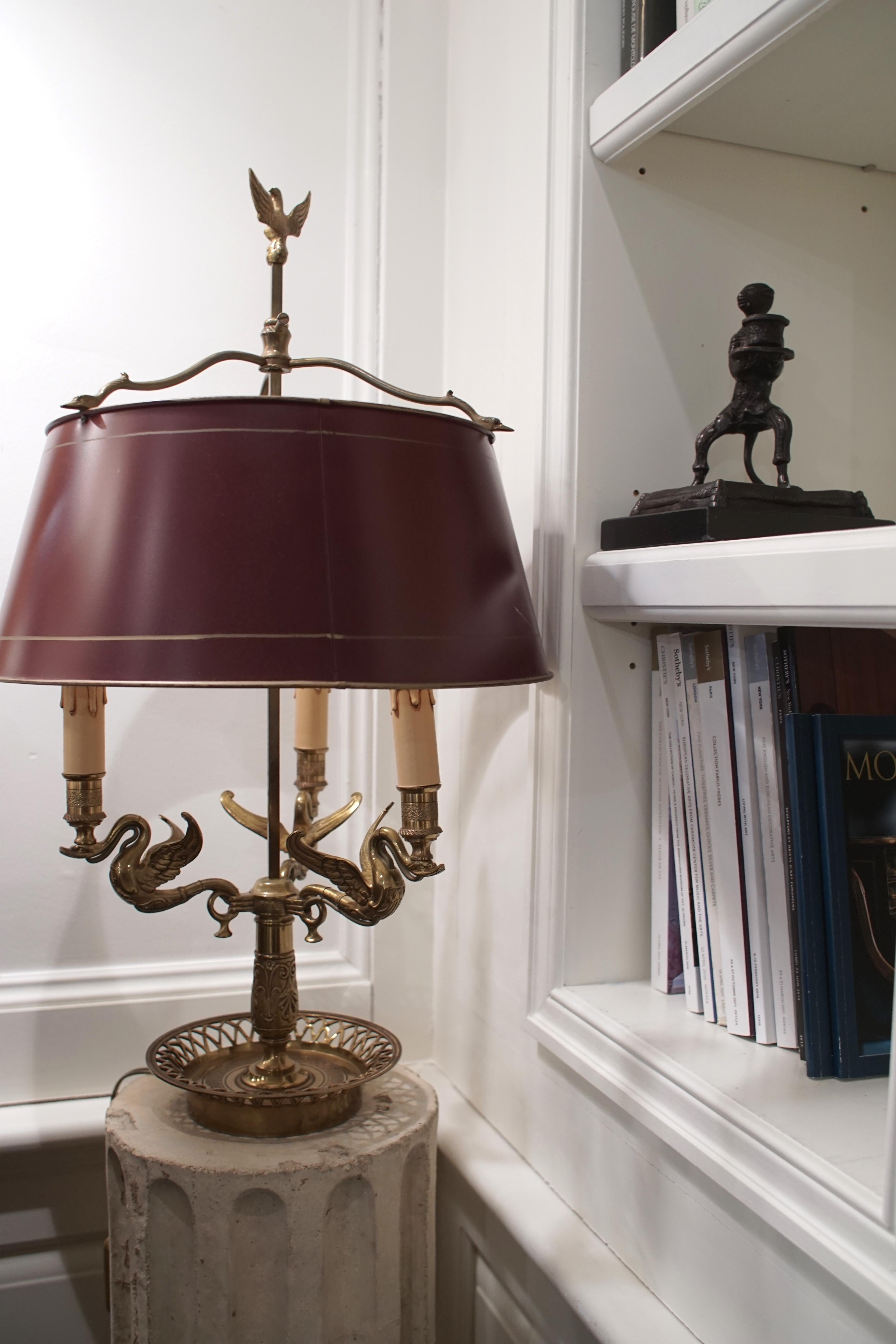 Empire style bronze 3-arm “Bouillotte” lamp with red Tôle shade. Classic Empire symbols of the eagle finial and swan necks

Dimensions: 26” H x 15.5” W x 15.5” D
Base diameter 7.25”.