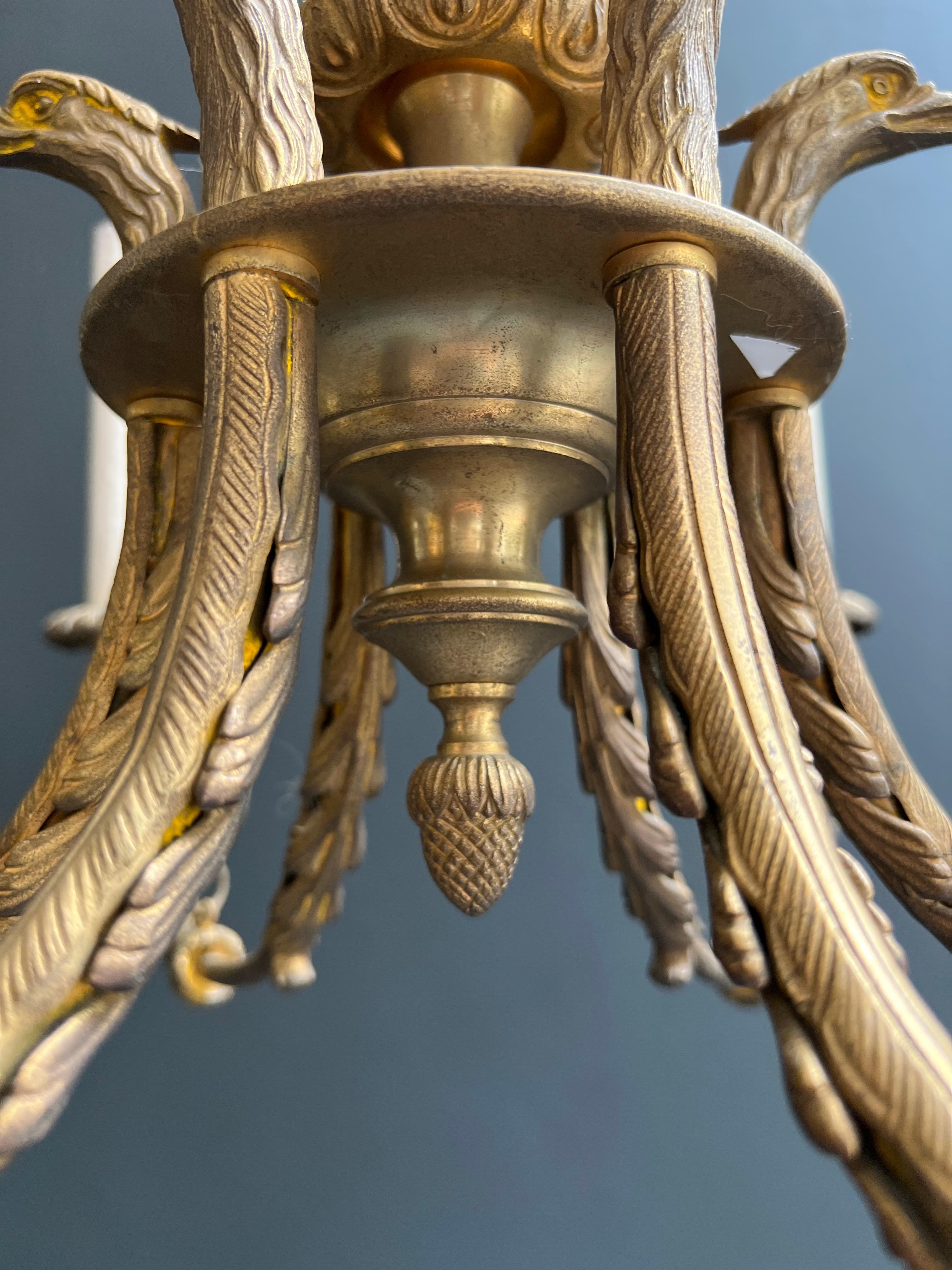 Araña de bronce de estilo imperio con cabezas de águila real y llama. Esta lámpara de araña en venta 4