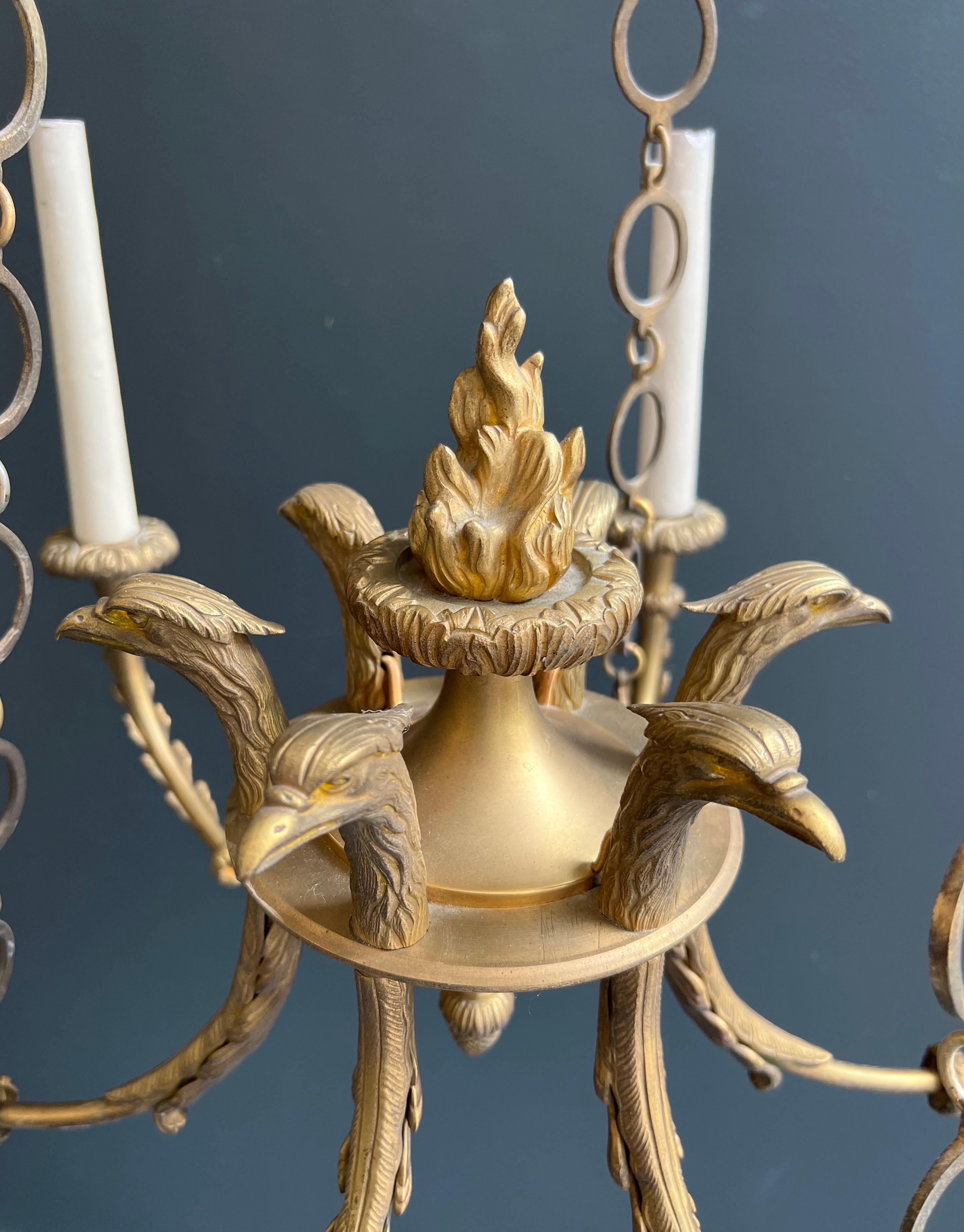 Araña de bronce de estilo imperio con cabezas de águila real y llama. Esta lámpara de araña en venta 6