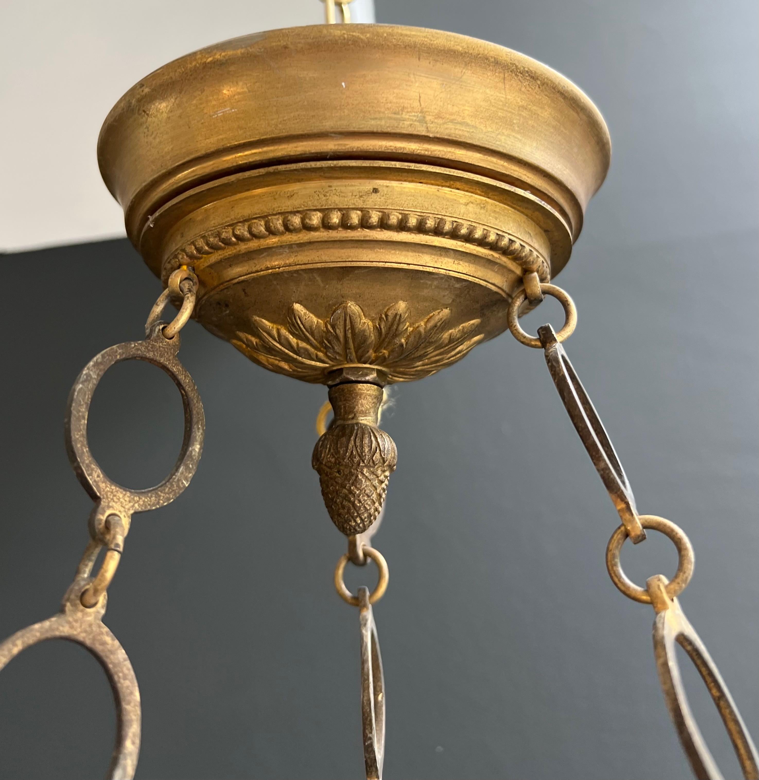 Araña de bronce de estilo imperio con cabezas de águila real y llama. Esta lámpara de araña Francés en venta