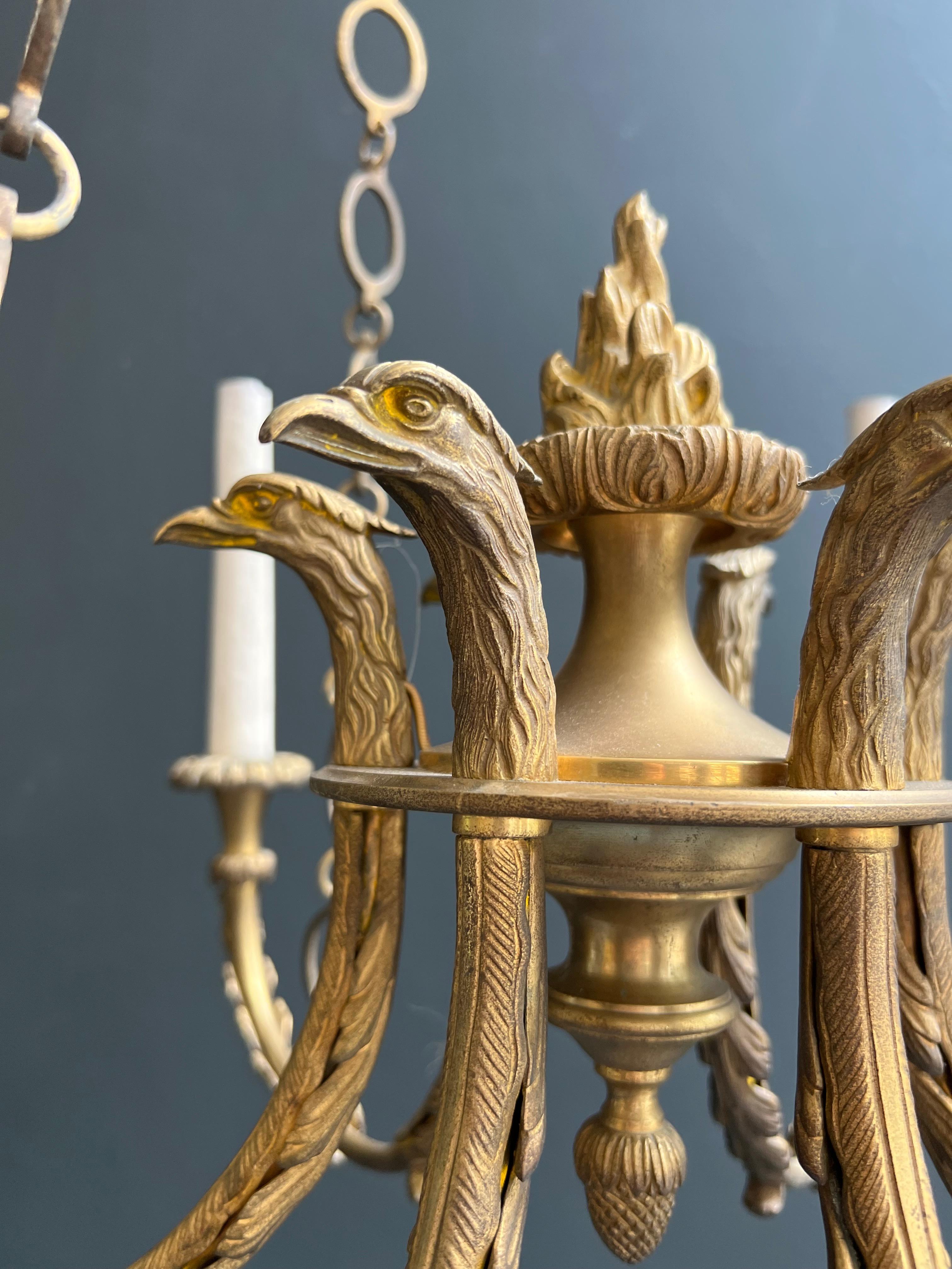 Araña de bronce de estilo imperio con cabezas de águila real y llama. Esta lámpara de araña en venta 2
