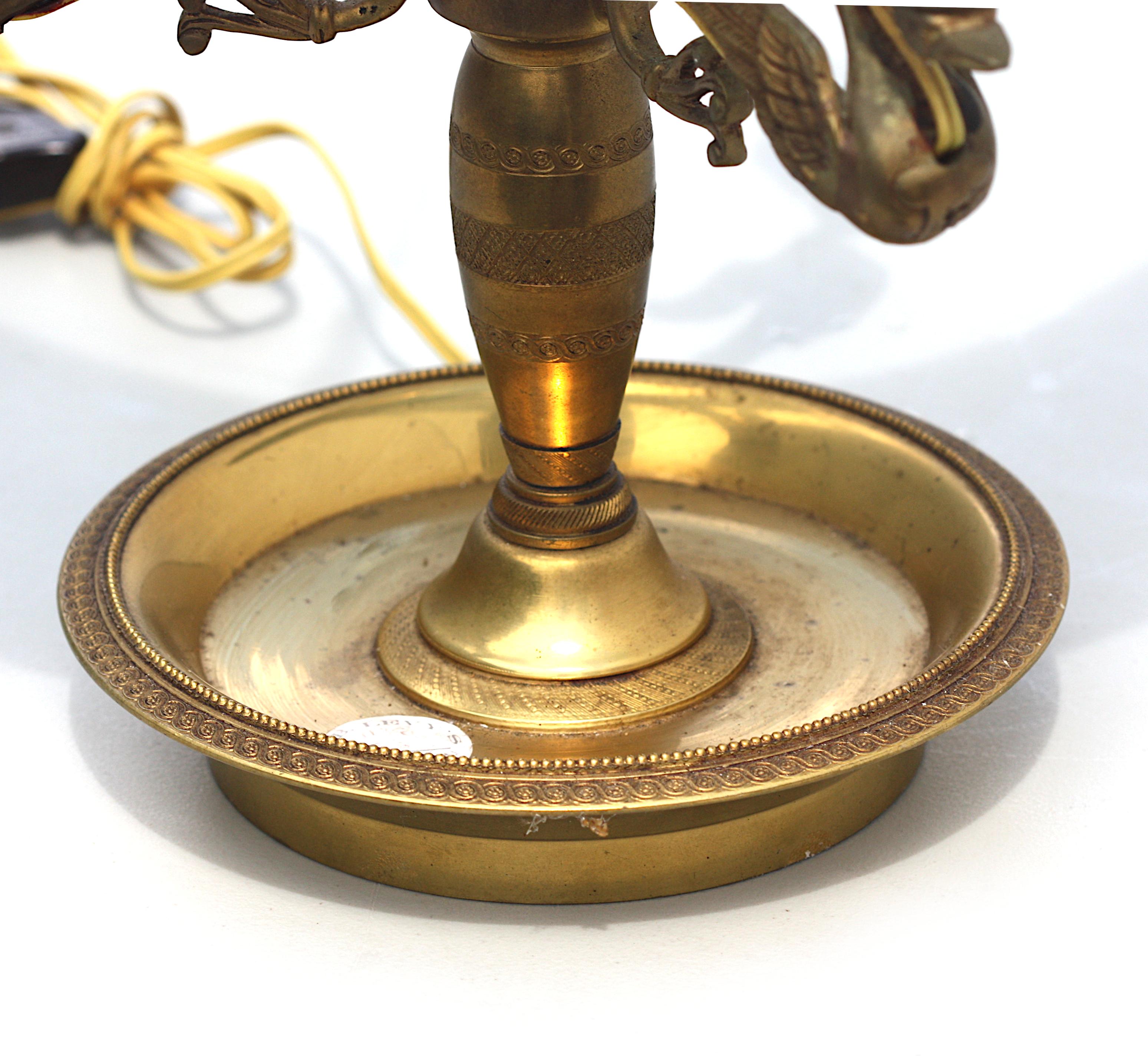 
Empire Style Bronze Three-Light Bouillotte Lamp
French, circa 1900. Cast with three swans, with a green tole shade.
Height 26 in., Diameter of shade 15.5 in.
Condition Report
Shade readjusted. Minor cosmetic surface issues