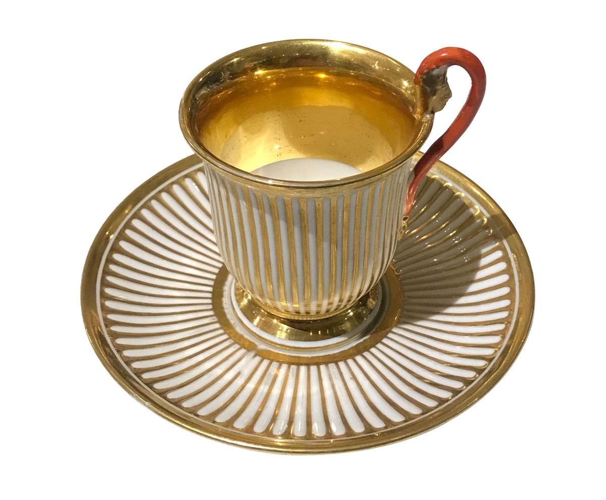 Sehr seltenes Kaffeeservice bestehend aus 5 Stücken: 4 Tassen mit Untertasse und 1 Zuckerdose. Ganzes Set aus Porzellan mit Streifenmuster aus Gold. Die Griffe sind rot bemalt und mit einer vergoldeten Figur im ägyptischen Stil versehen. Innenteil
