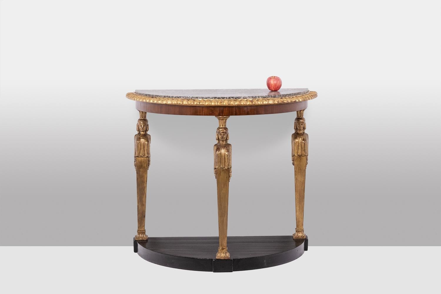 Empire style console in half-moon shape, decorated with caryatids, or canephora, in carved and gilded wood with its cap and drape, the base and belt in mahogany, with its granite marble top.

French work realized circa 1880.

Dimensions: H 82 x W 98