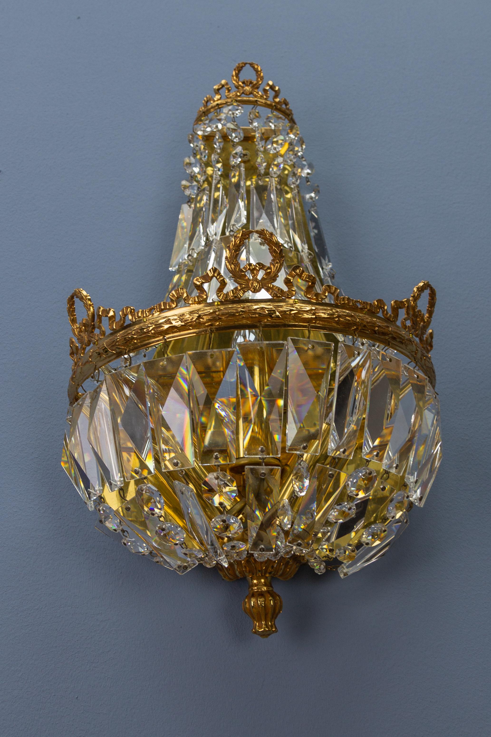 A splendid Empire-style sconce by Palwa, Germany, 1960s. Gilt brass frame adorned with crystal glass beads and prisms, three interior lights for E14 size light bulbs.
Dimensions:
Height: 38 cm / 14.96 in; width: 22 cm / 8.66 in; depth: 13 cm / 5.11