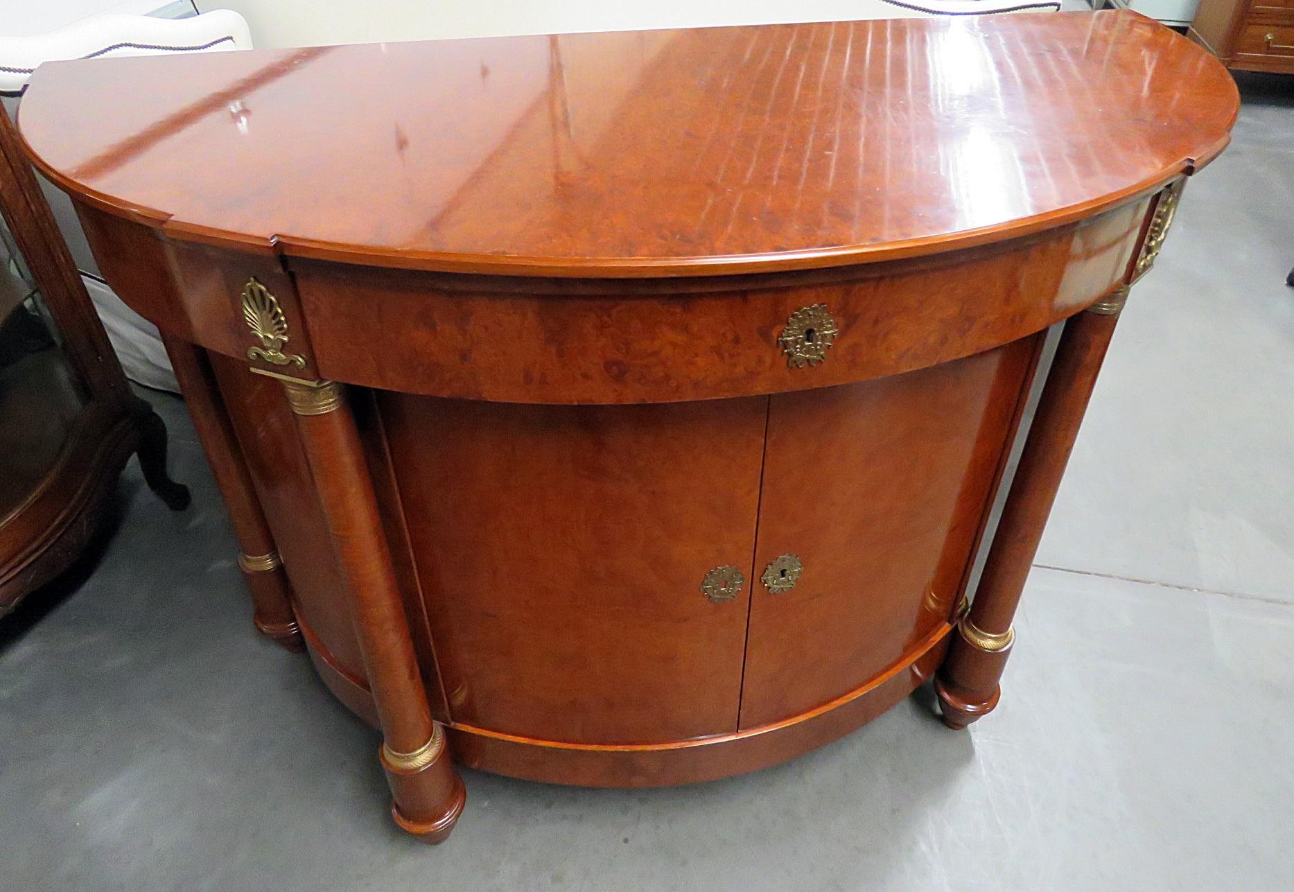 Empire style demilune commode with 1 silver drawer over 2 doors containing 1 shelf.