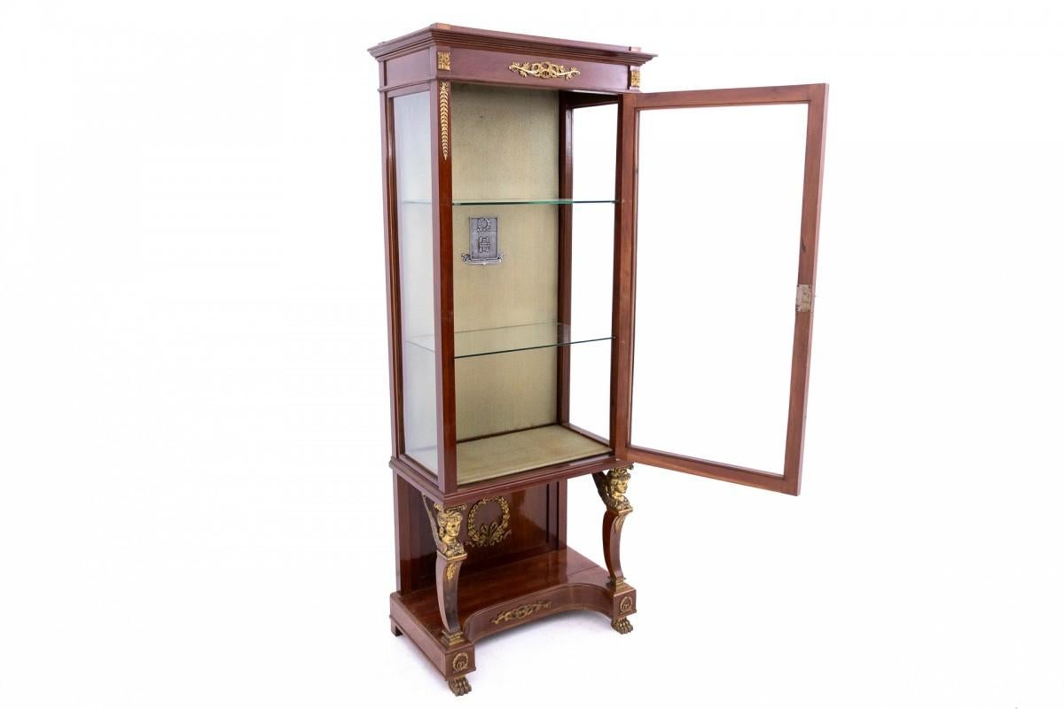 Vetrina in stile impero della fine del XIX secolo, proveniente dall'Europa meridionale. Riccamente decorata con elementi decorativi in ottone, dotata di due pratici ripiani in vetro.

Wood: Mogano.

Attualmente in fase di