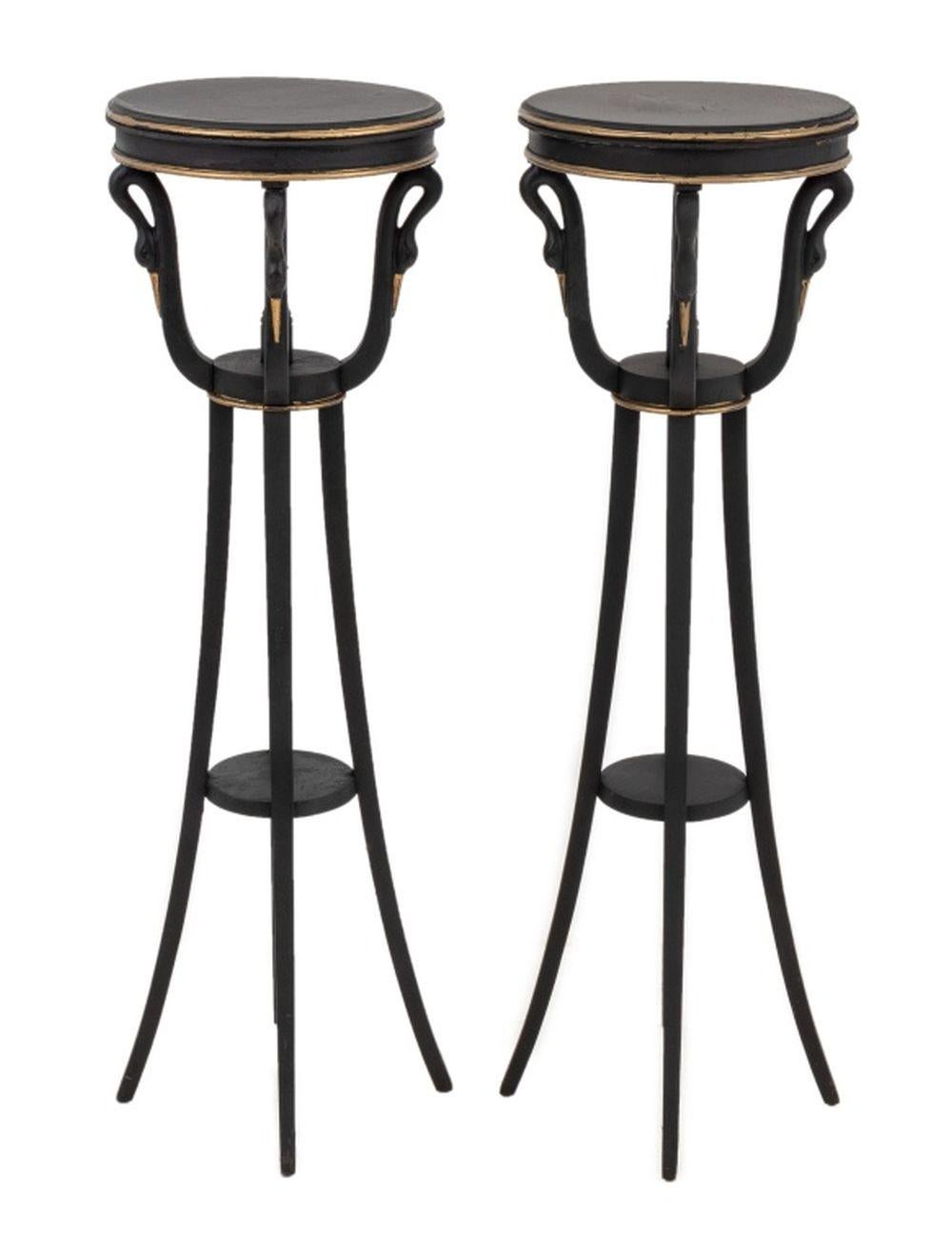 Pair of Empire Style Ebonized and Gilt Painted Wood Pedestals, 20th century, each with a circular molded top above scrolled swan neck supports, on splayed legs joined by an undertier. 42