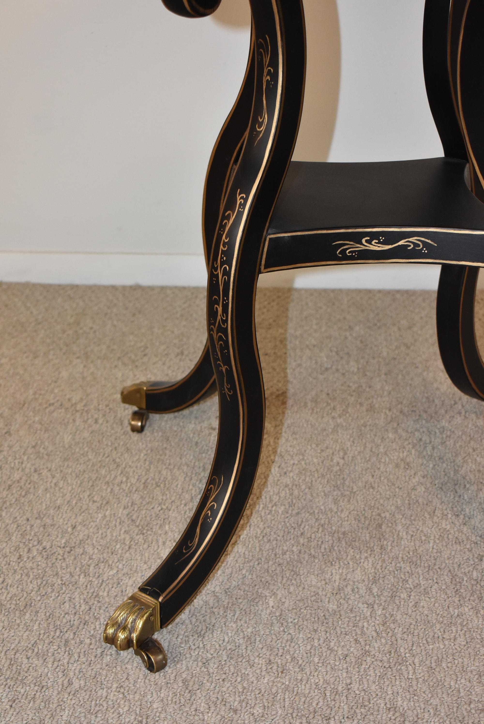 Empire style eglomise mirrored round center table. Black finish painted leaf details and trim in gold. Distressed mirror top.