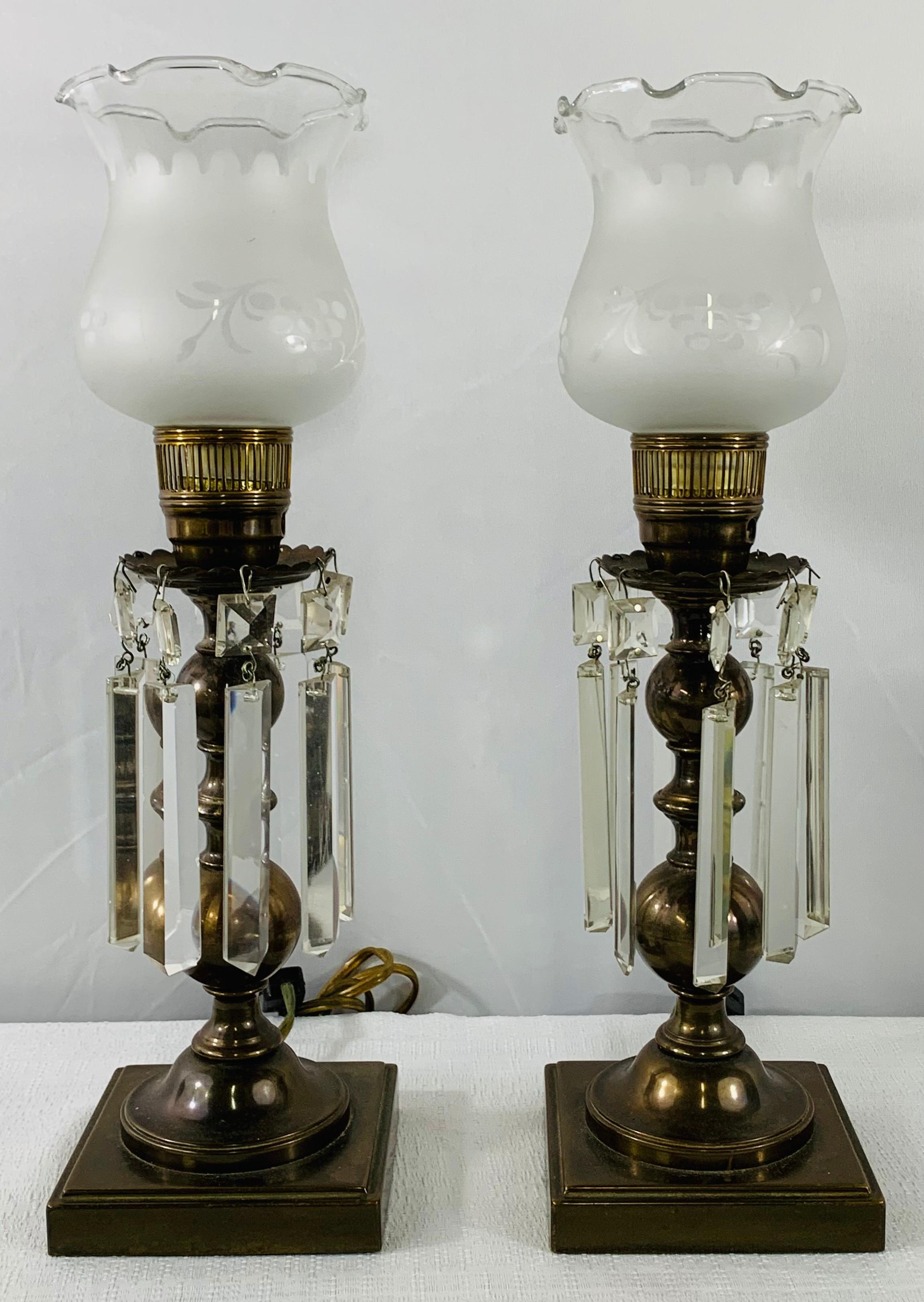 A classic pair of Empire style English classic hurricane table lamps each has 9 crystal prisms hanging around the lamp column. The original Milk glass shades are hand cut and have floral motifs on each.


 