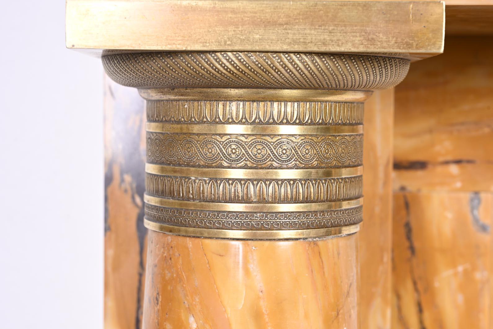 Francese Caminetto in stile impero in marmo giallo Siena con colonne e rosone in bronzo dorato in vendita