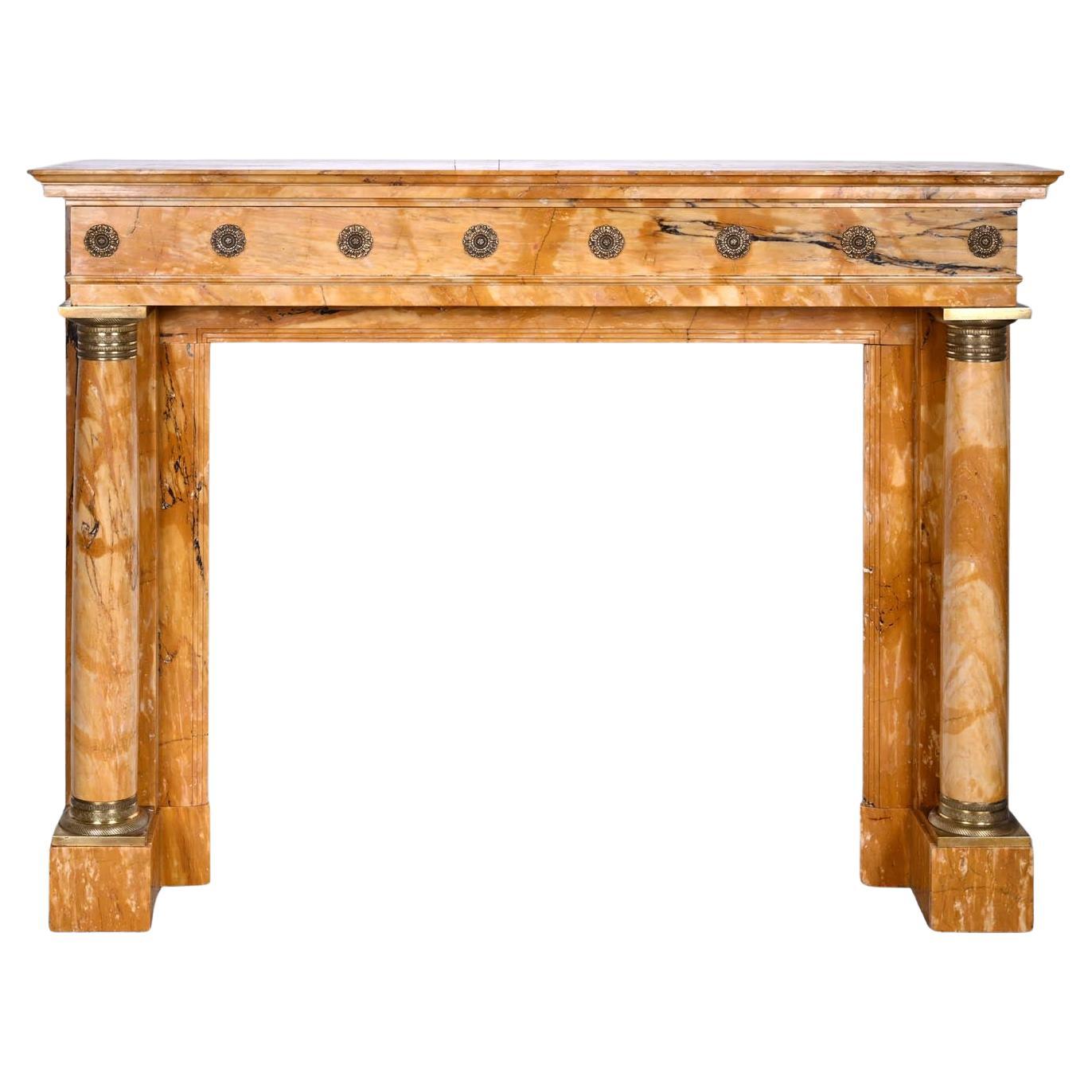 Caminetto in stile impero in marmo giallo Siena con colonne e rosone in bronzo dorato in vendita