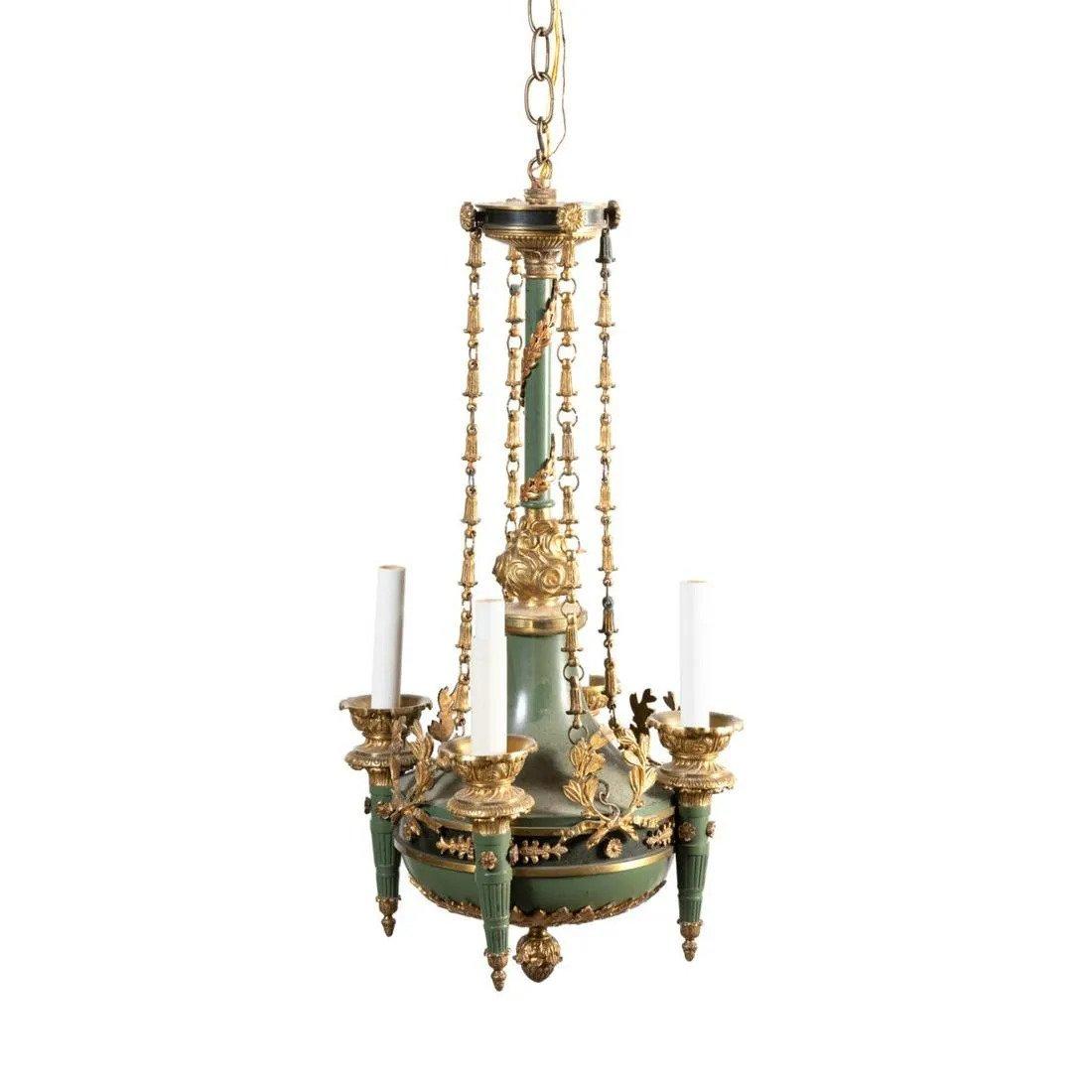 Lustre de style Empire, à quatre lumières en forme de colza, décorées de peinture verte, avec des accents feuillagés en bronze doré, avec des bras en forme de torche. France, vers 1900. 4 lumières.
Dimensions : Hauteur 26