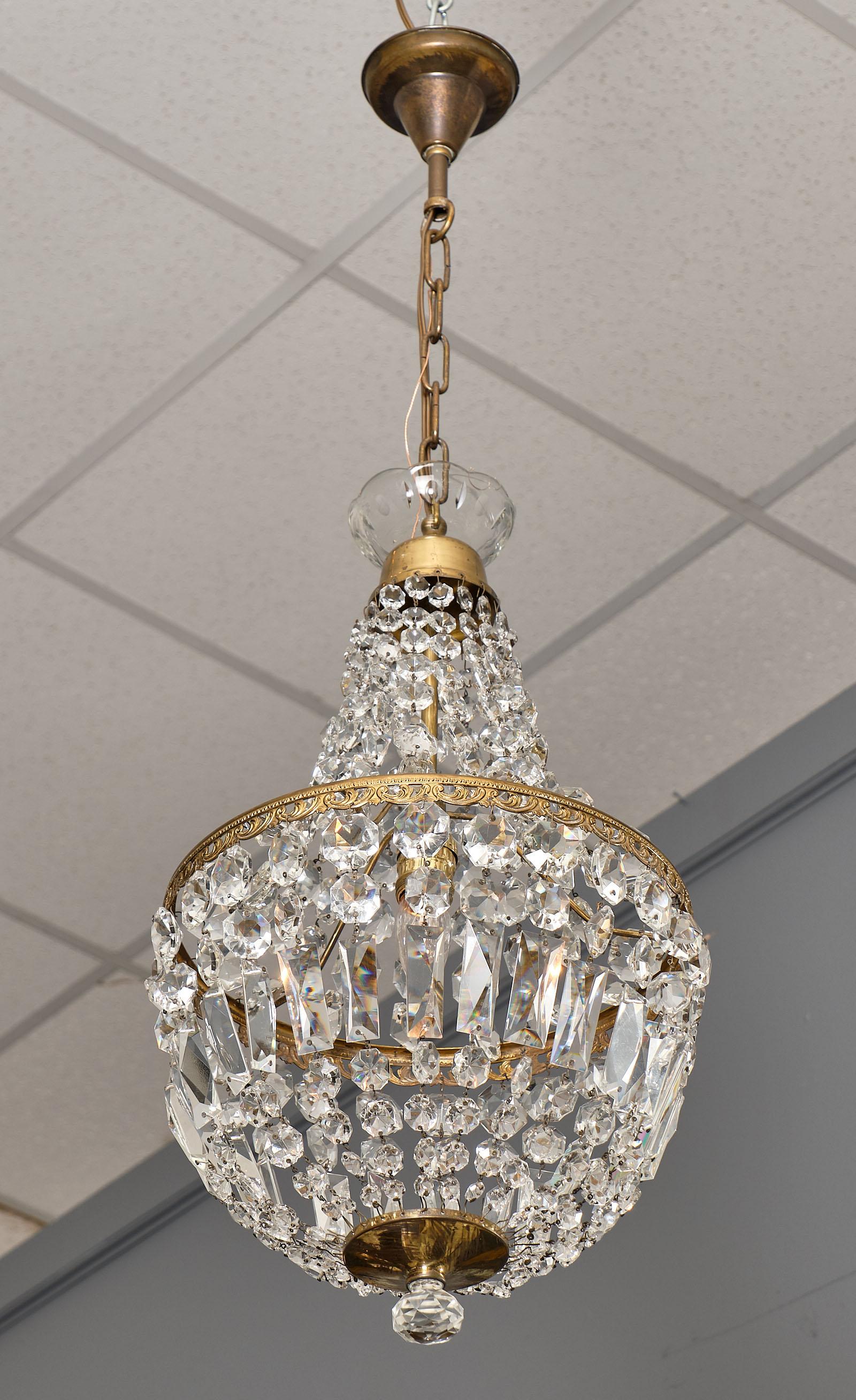 Early 20th century French Empire style crystal chandelier with gilt embossed brass details. This piece has been rewired for the US market. The height from ceiling is 37.5