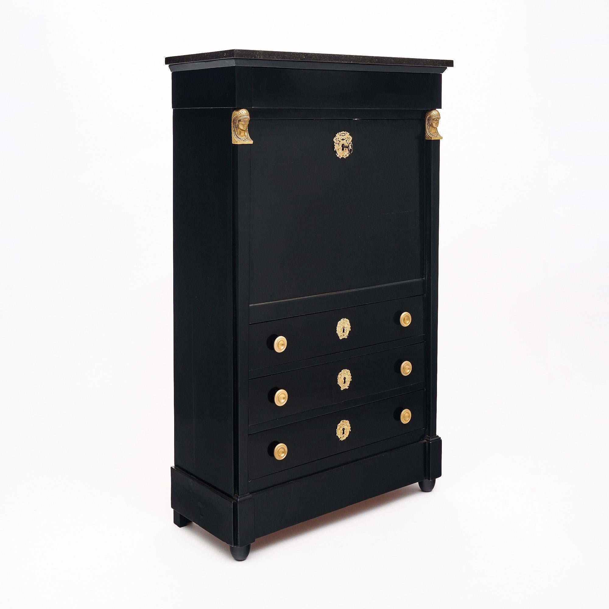 Secretary from France in the Empire style. This piece is made of mahogany that has been ebonized and finished with a lustrous French polish of museum quality. The cabinet boasts two bronze Egyptian pharaoh busts at the top of the sides. The drop