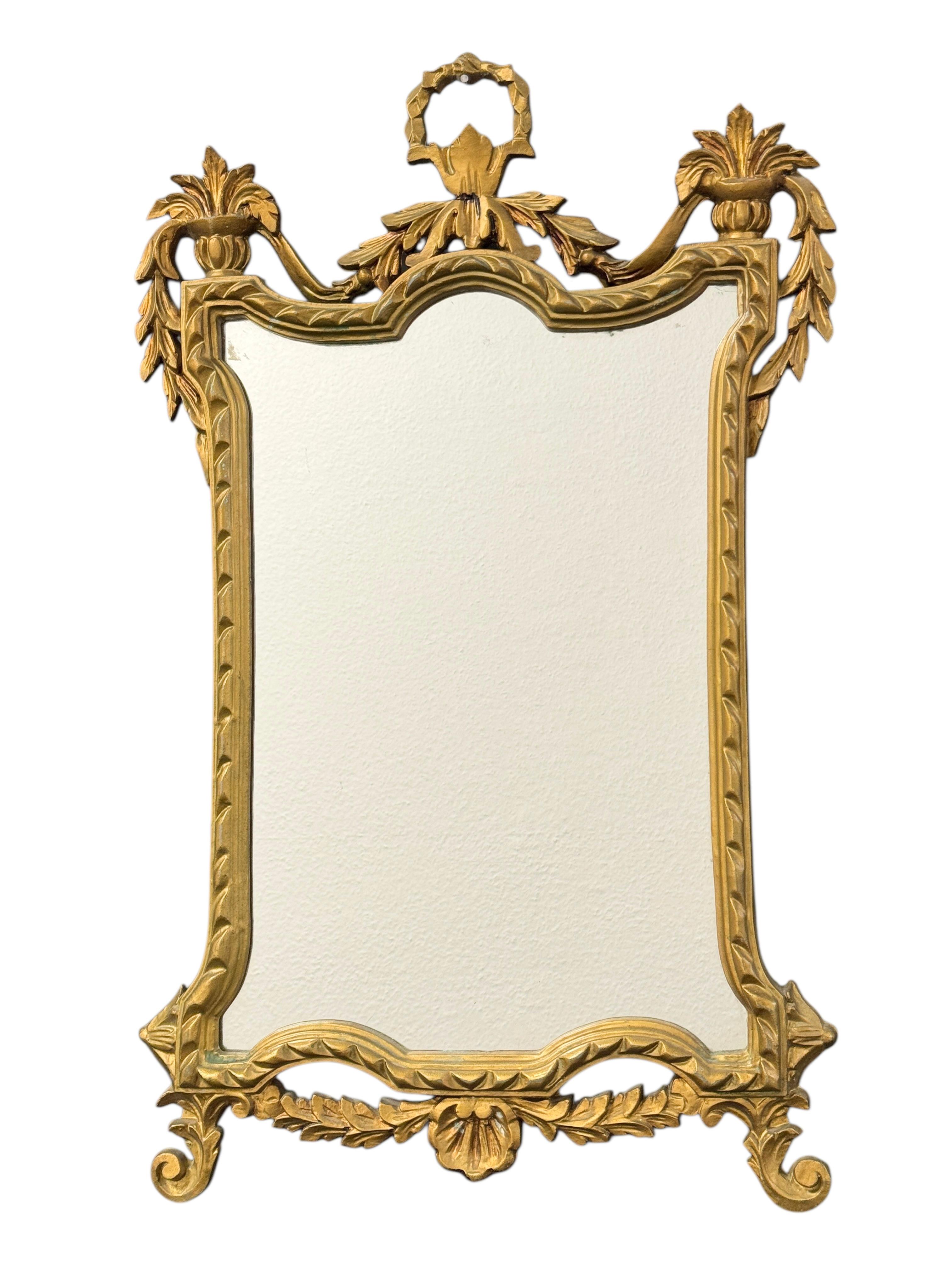 Stunning Empire style toleware mirror. The gilded resin or plastic frame surrounds a glass mirror. Made in Italy, circa 1950s. Beautiful mirror for any room or your hall entry. Nice addition to any room. Marked made in Italy.