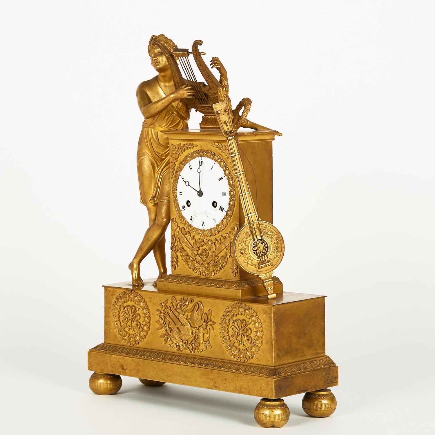 Empire style gilt bronze clock from the 19th century.

19th century Empire style gilt bronze clock with porcelain dial, minor restoration to the porcelain to be expected, movement to be revised.
h: 53cm, w: 34cm, d: 14cm