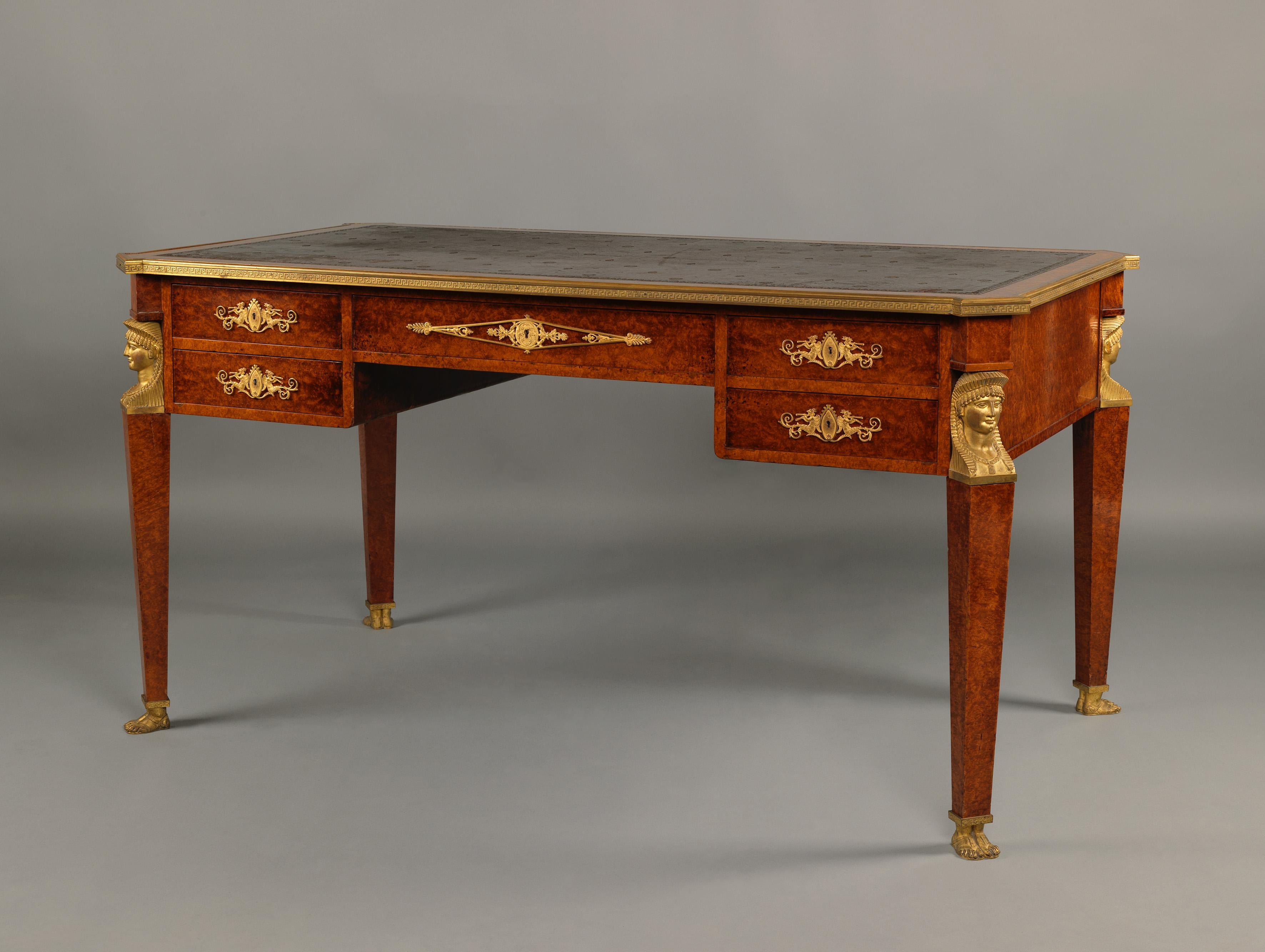 An Empire style gilt-bronze mounted bureau plat by Maison Forest.

Paris, circa 1900.

Bearing two labels to the underside: 'FOREST/TAPISSERIE/EBENISTERIE/31 RUE CAMBACERES.PARIS'.

This fine burr amboyna veneered bureau plat has a gilt-tooled