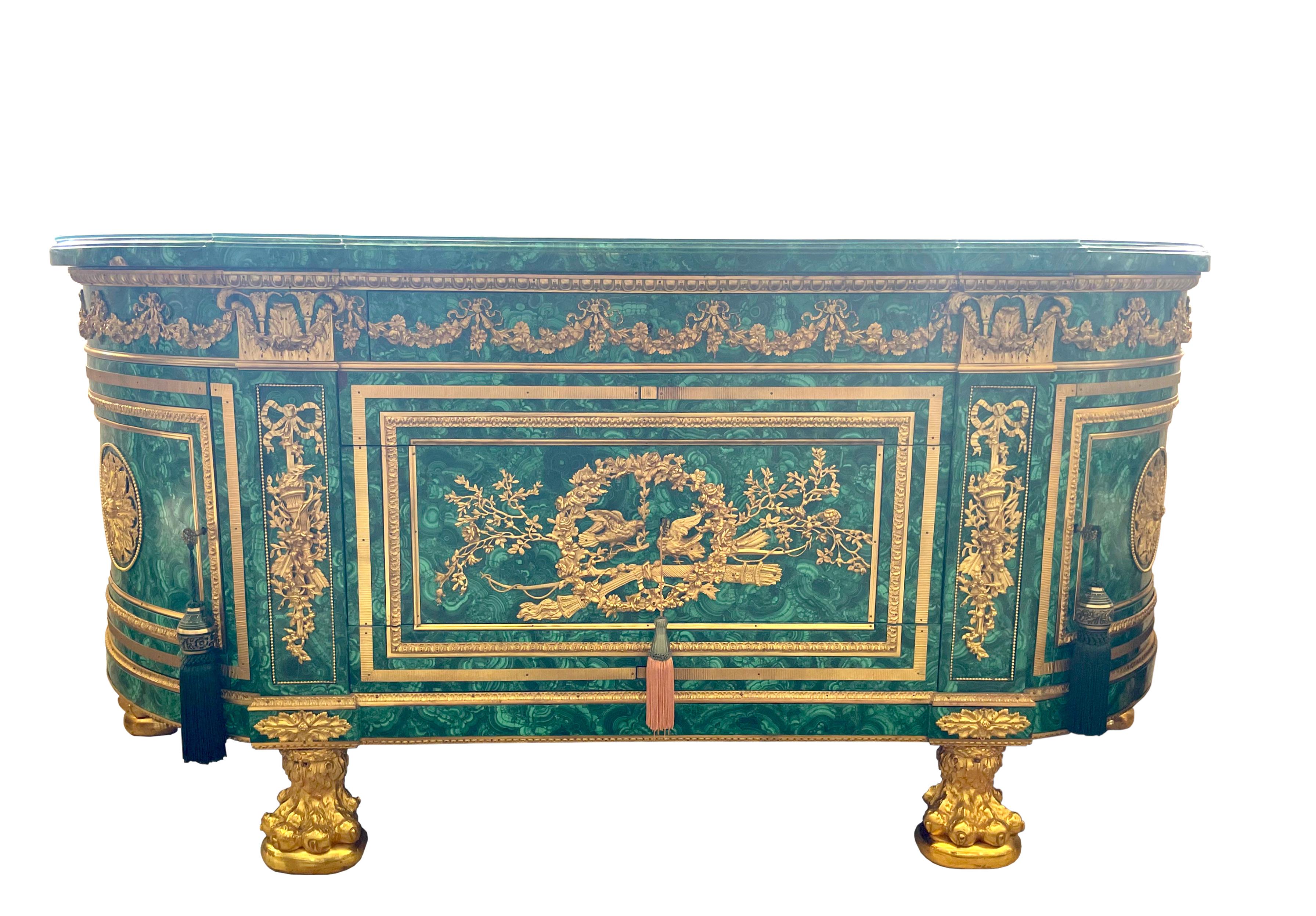 
Empire Style Gilt Bronze Mounted Malachite Commode
Late 19th Century.The shaped malachite veneered top above a conforming case, fitted with two drawers flanked by cabinet doors, on gilt bronze lions paw feet, the whole mounted with bronze