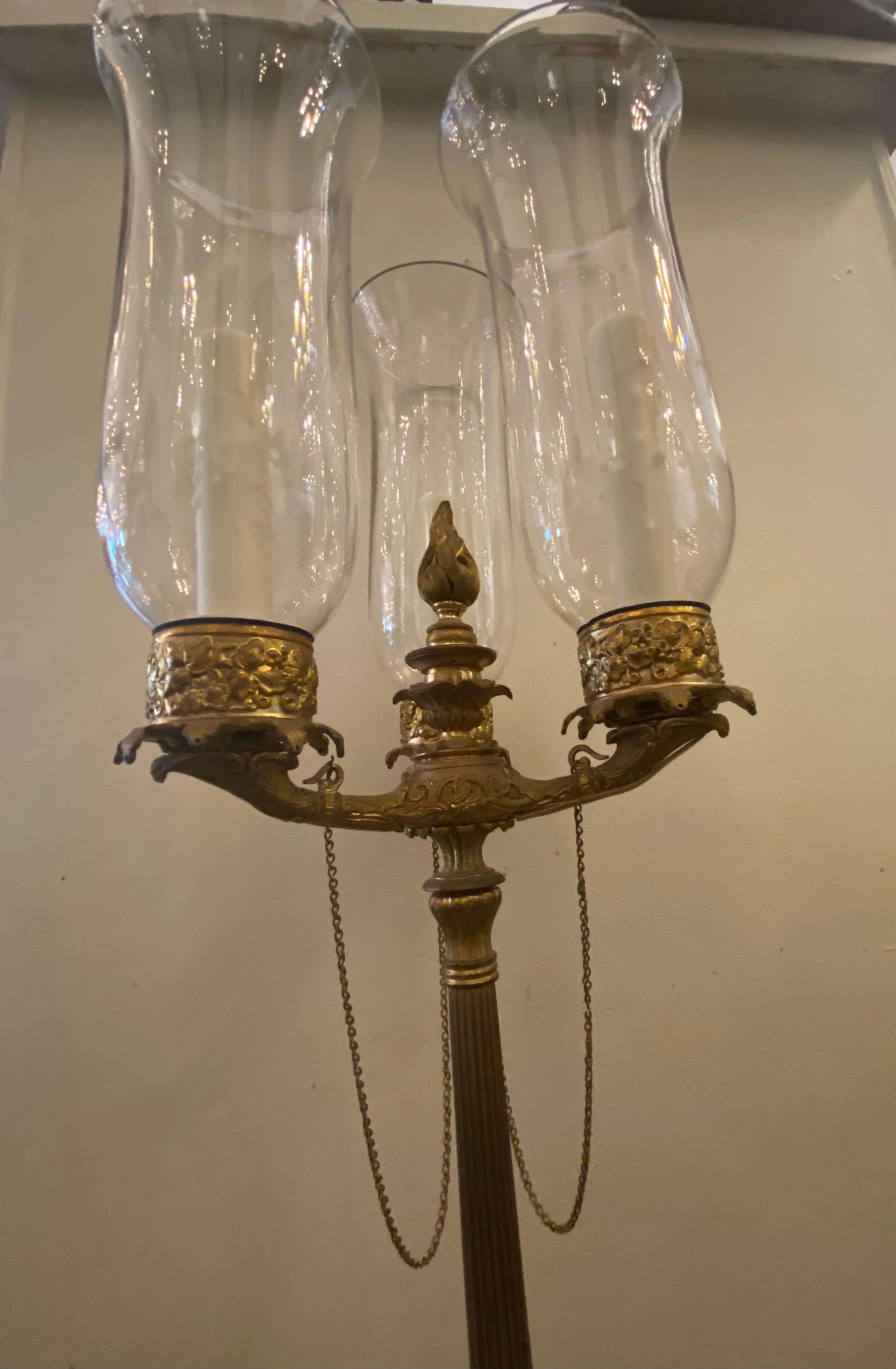 Empire style table lamp, having three candles arms each fitted with a socket and a glass hurricane, electrified with 3-6