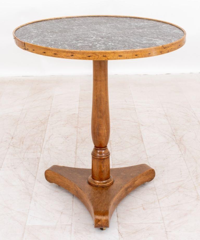 Empire style gueridon table with black and white marble circular top within a beechwood frame, on baluster-form column support atop an incurved tripod base. 

Dealer: S138XX