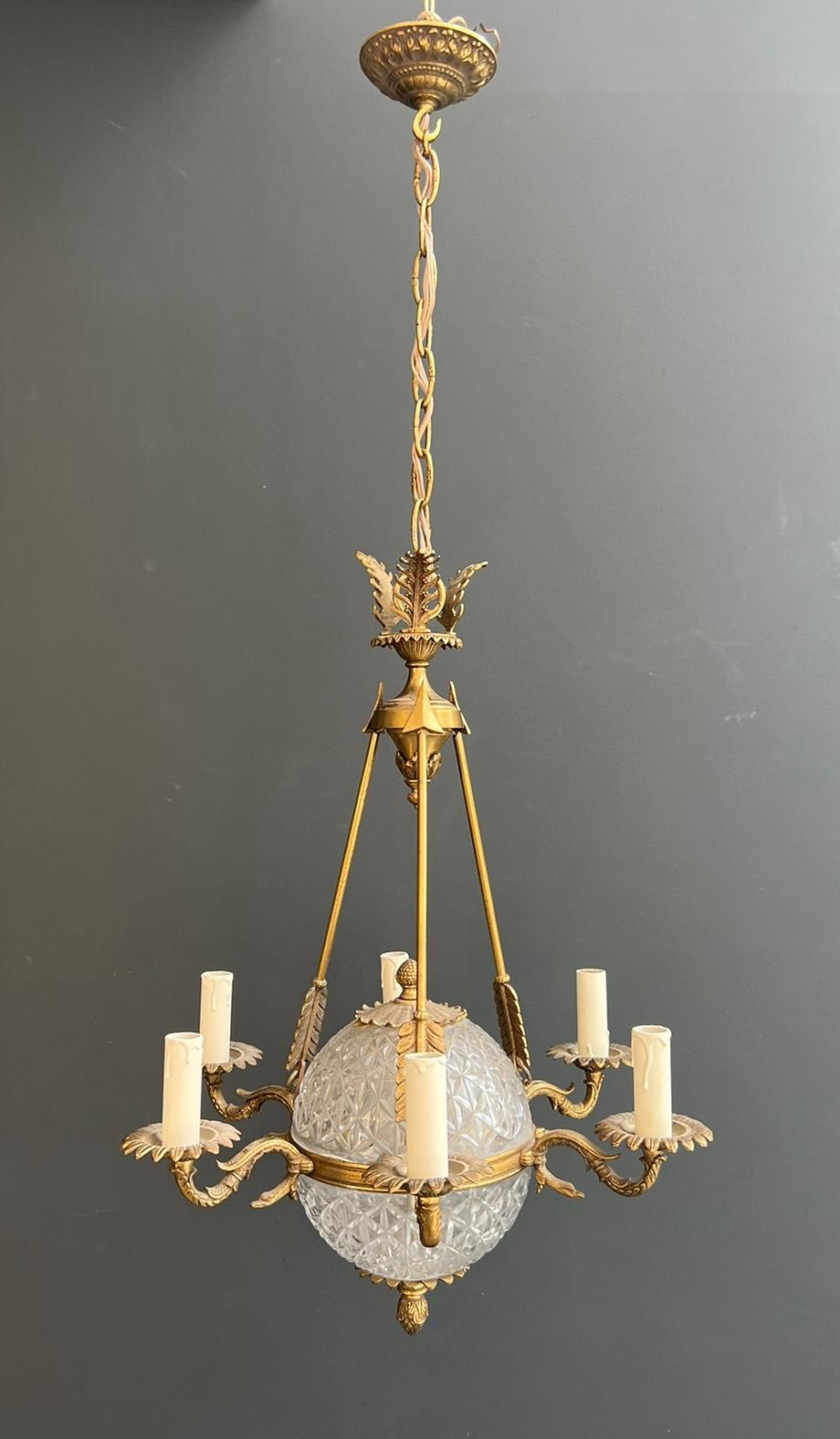 Questo lampadario a mongolfiera in stile Eleg, molto bello ed elegante, è realizzato con  bronzo e cristallo al piombo. L'apparecchio è decorato con frecce e colli di cigno. Si tratta di un'opera francese di pregio. Circa 1940
