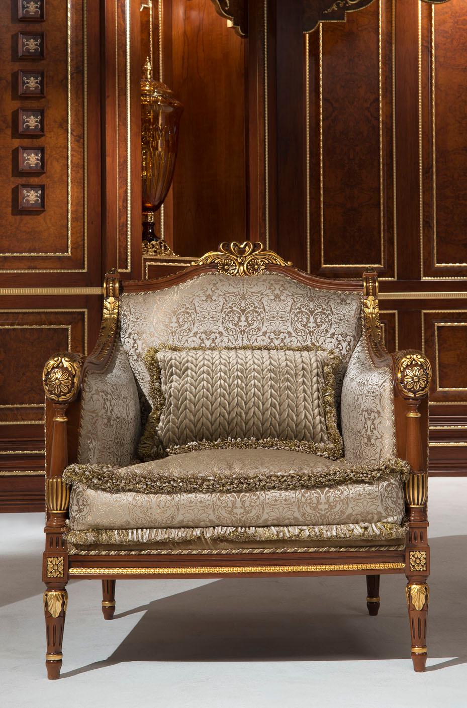 Exquisitely carved armchair in walnut finish with gold leaf decorations. Cushion and fabrics are 100% customizable, this particular model uses an exclusive grey damascus. This majestic piece of Made in Italy furniture fits perfectly in a cozy living