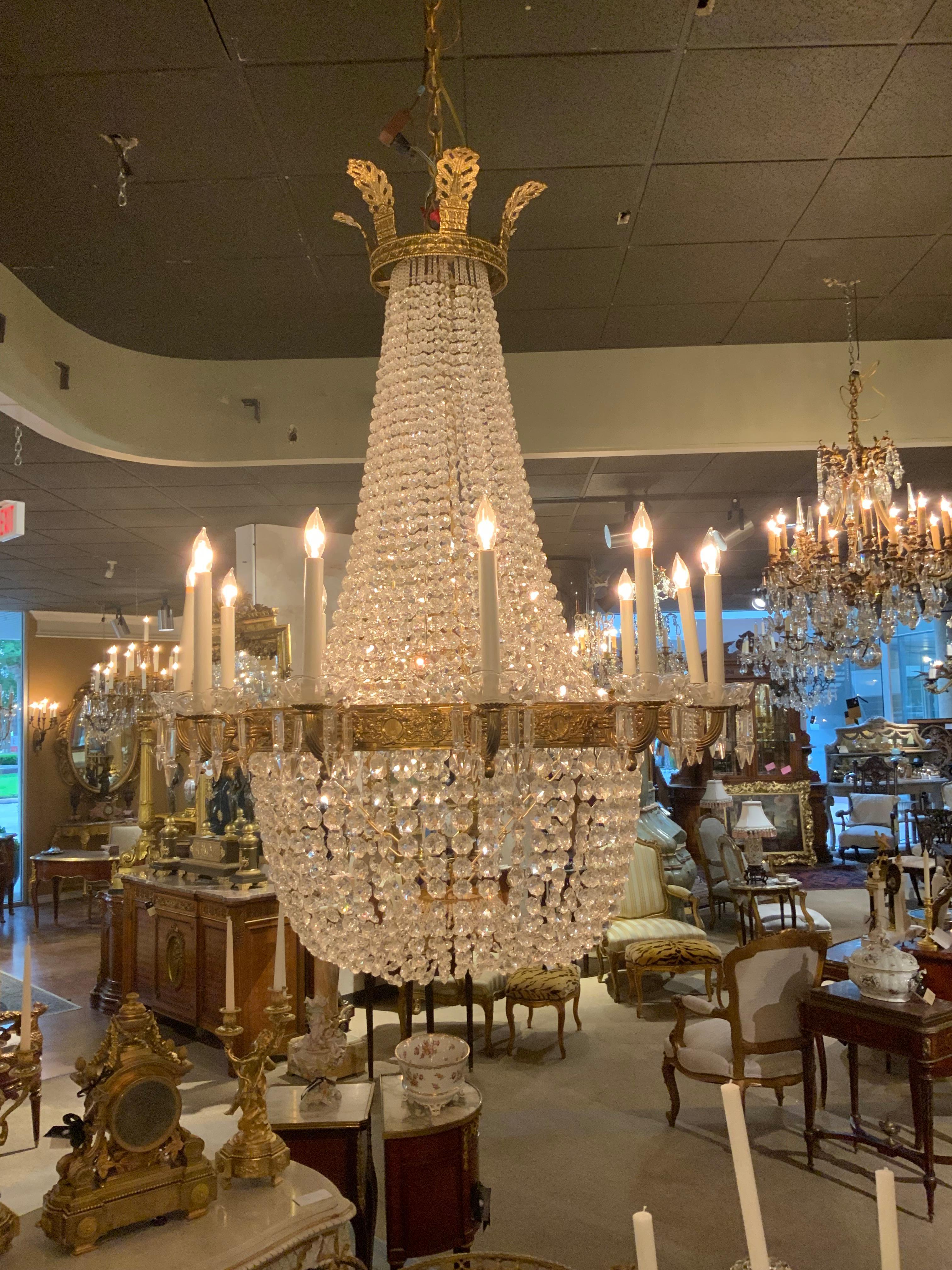Lo stile elegante rende questa lampada molto desiderabile.
Ha una corona sulla cresta e presenta cristalli brillanti.
Che scendono a cascata verso il basso con una forma ad arco che collega
In una ciotola grande  formando una forma circolare.
Dodici