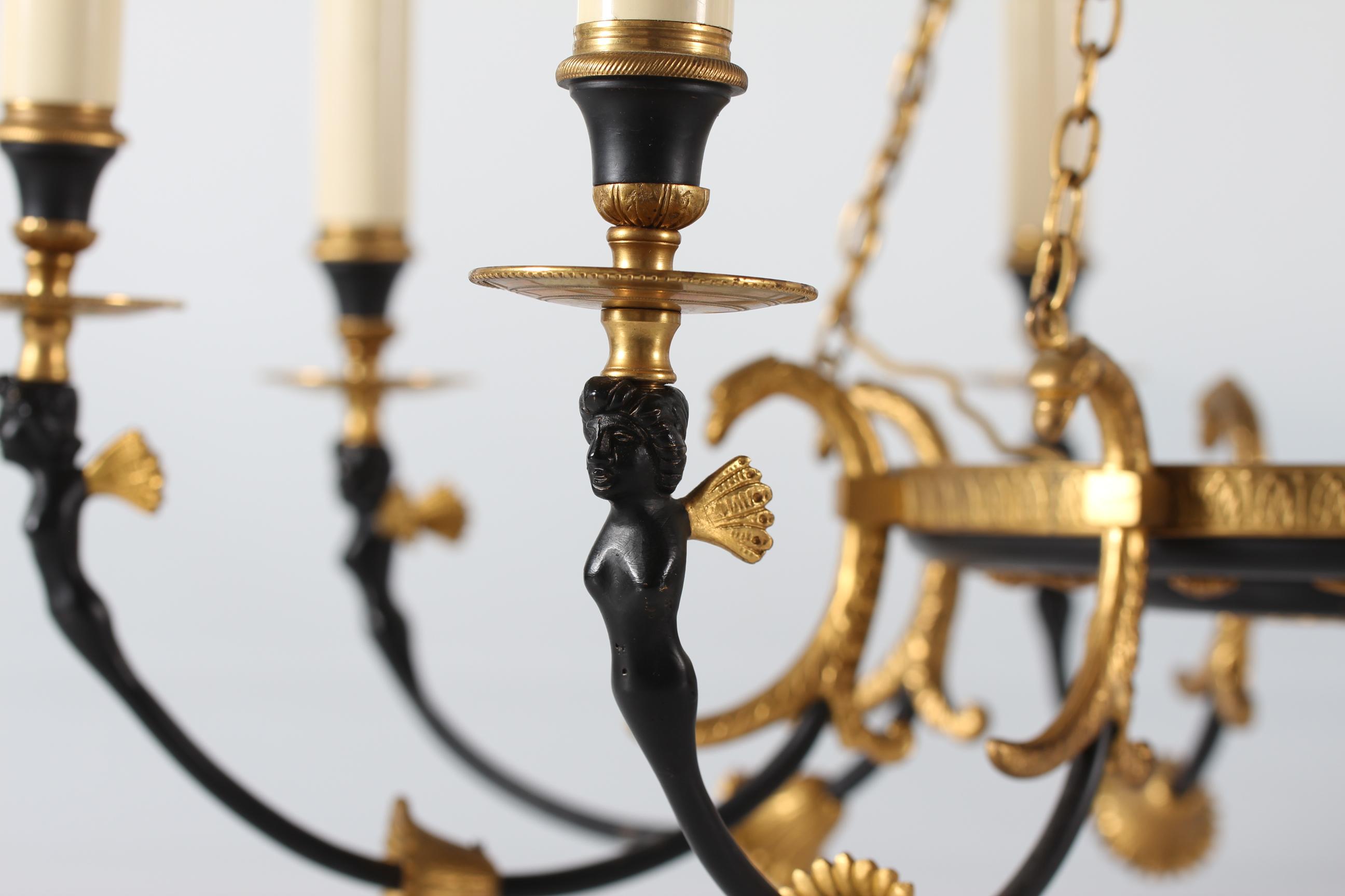 Large Empire style eight-armed chandelier made of a combination of gilded and black-patinated metal with women figures.
Manufactured in Denmark, circa 1920.

Very nice vintage condition with full function.


 