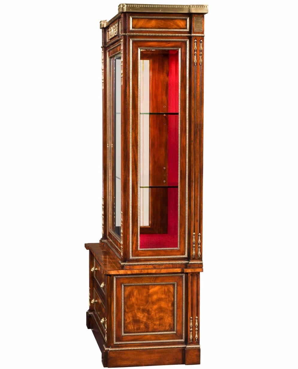 Empire Style Mahogany Bibliothèque (Display Cabinet) with Brass Mounts, a captivating piece that exudes timeless elegance and sophistication. Crafted from luxurious mahogany and adorned with finely cast brass mounts, this cabinet boasts unparalleled