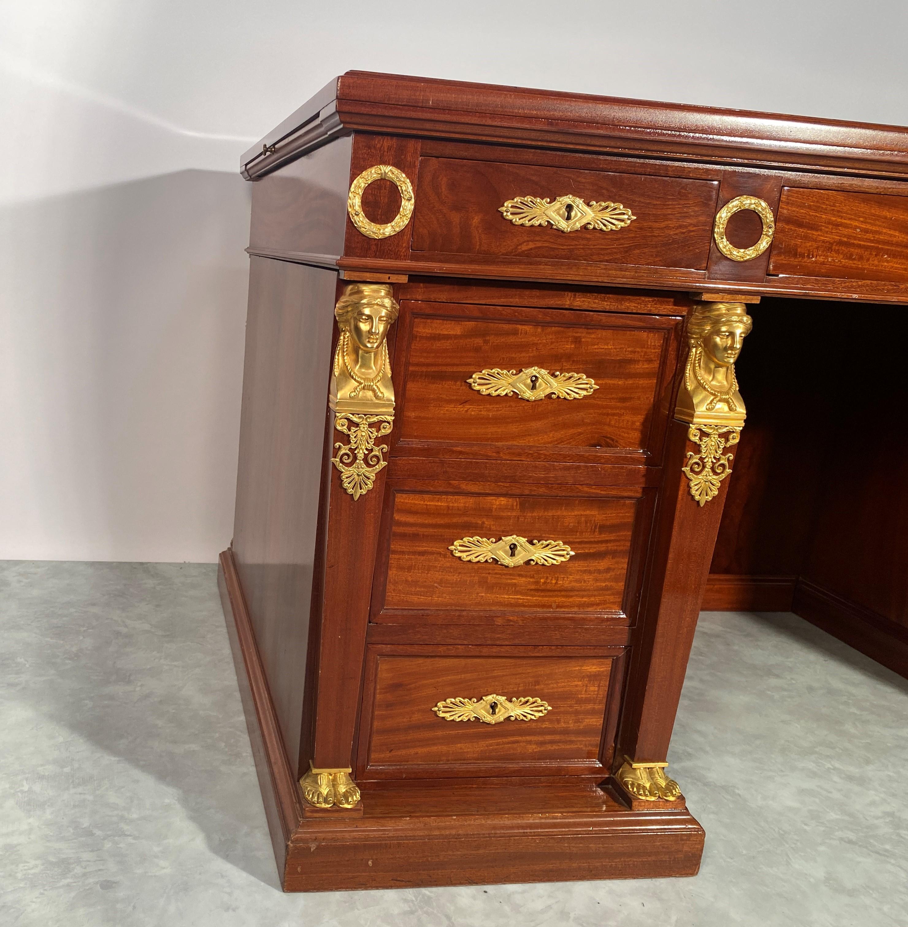 It is composed of two boxes and a central tray opening with nine drawers in total. The desk is in mahogany veneer of very fine grain quality, the color of the mahogany is not dark but rather soft, in harmony with the slightly darker soft veining