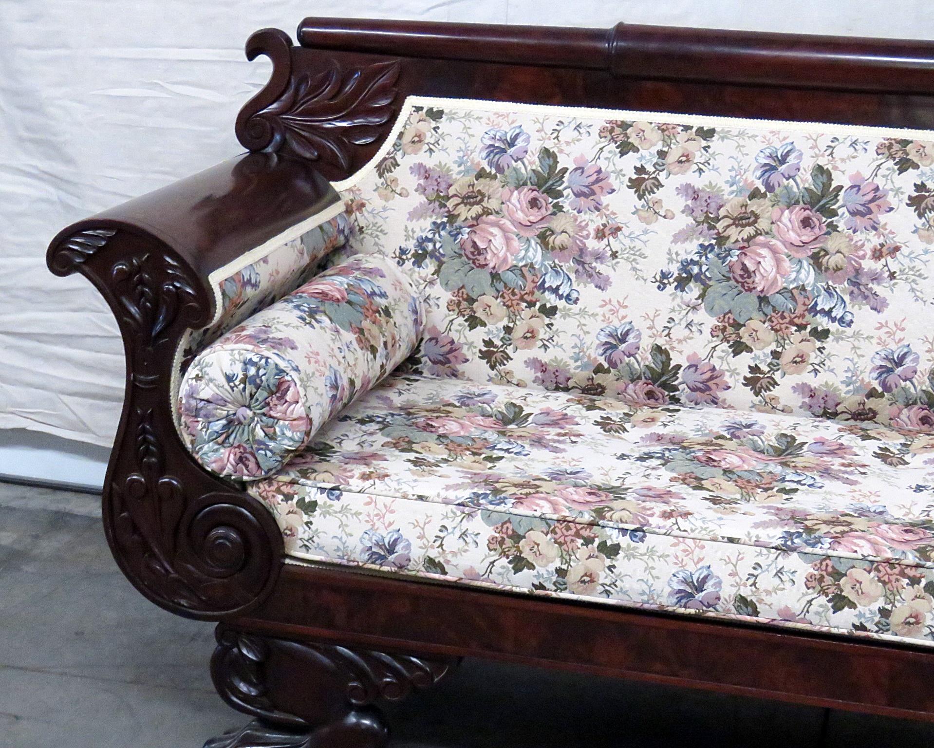 Empire style mahogany sofa with floral upholstery and 2 matching accent pillows on paw feet.