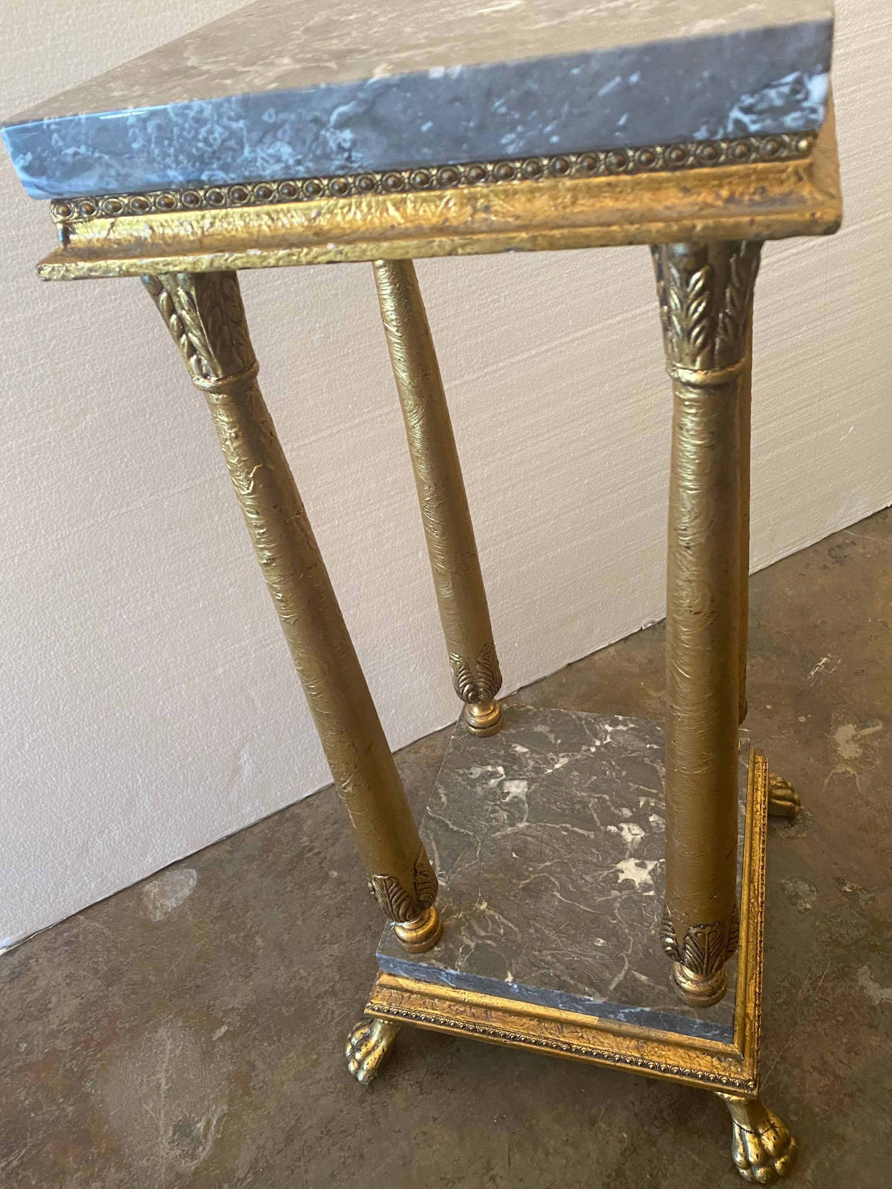 Empire style marble-top giltwood plant stand, having square top over four carved foliate columns, rising on marble base, ending in paw feet.